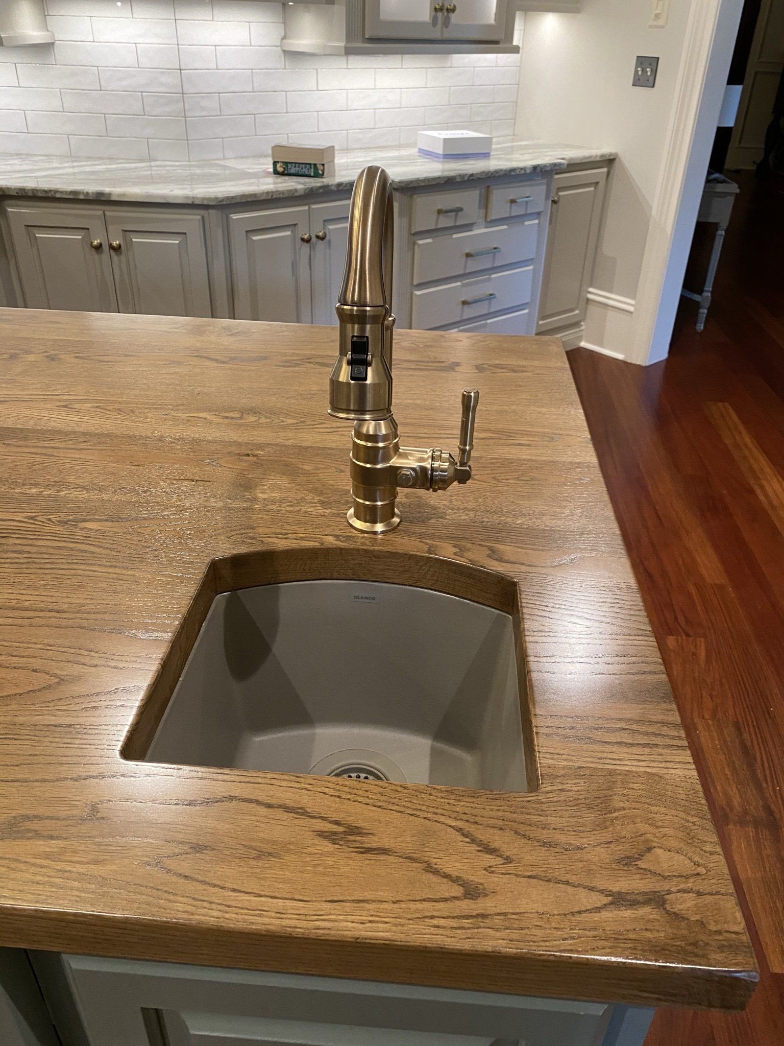 A kitchen sink with a faucet on top of a granite counter top.