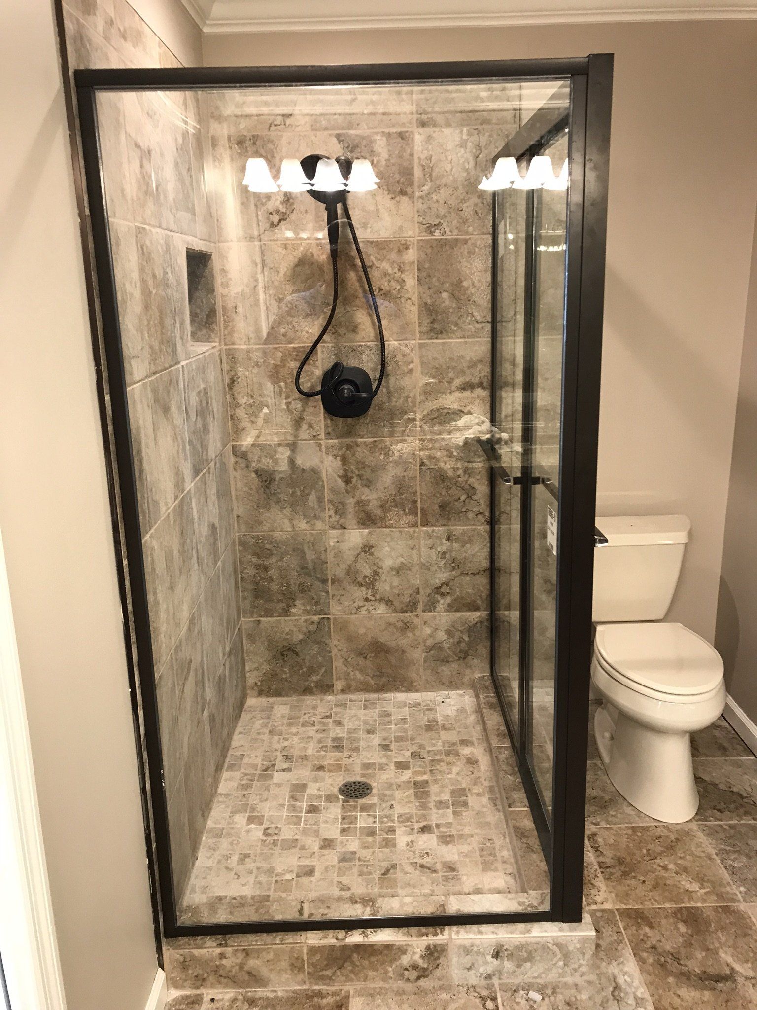 A bathroom with a walk in shower and a toilet.
