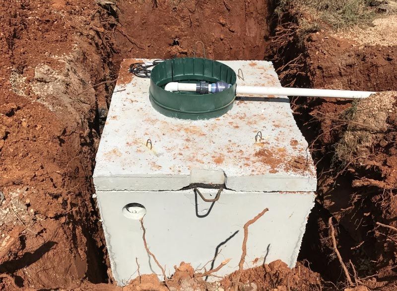 a septic tank is sitting in the middle of a dirt field in Huntsville Alabama