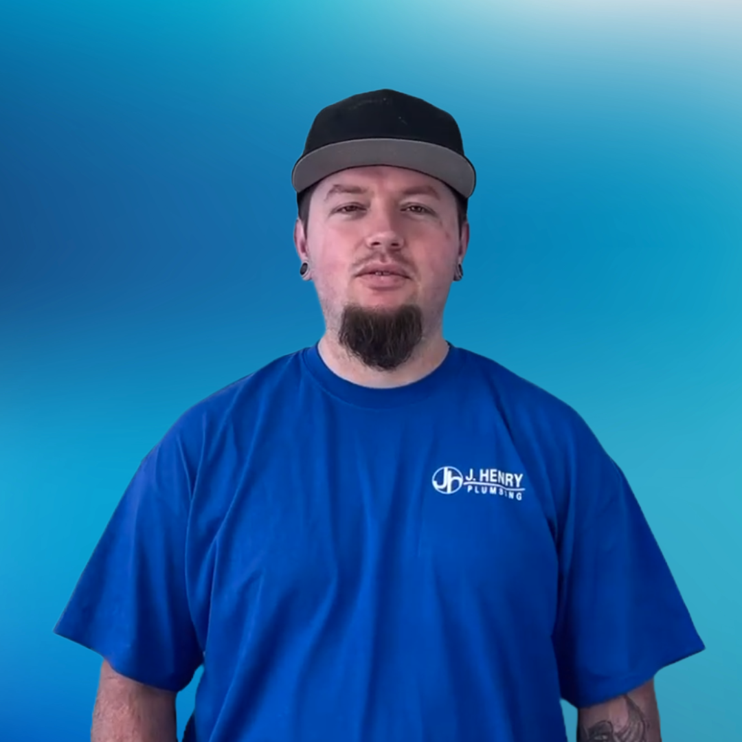 A man wearing overalls and a black shirt is smiling