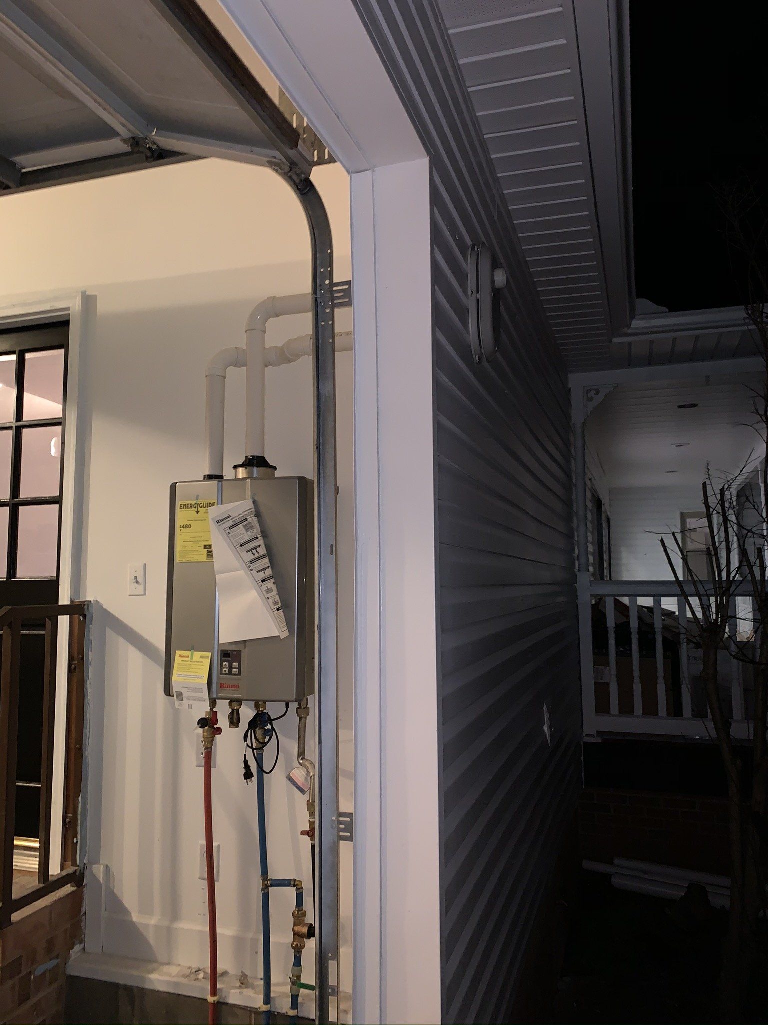 A garage door is open and a newspaper is hanging on the wall