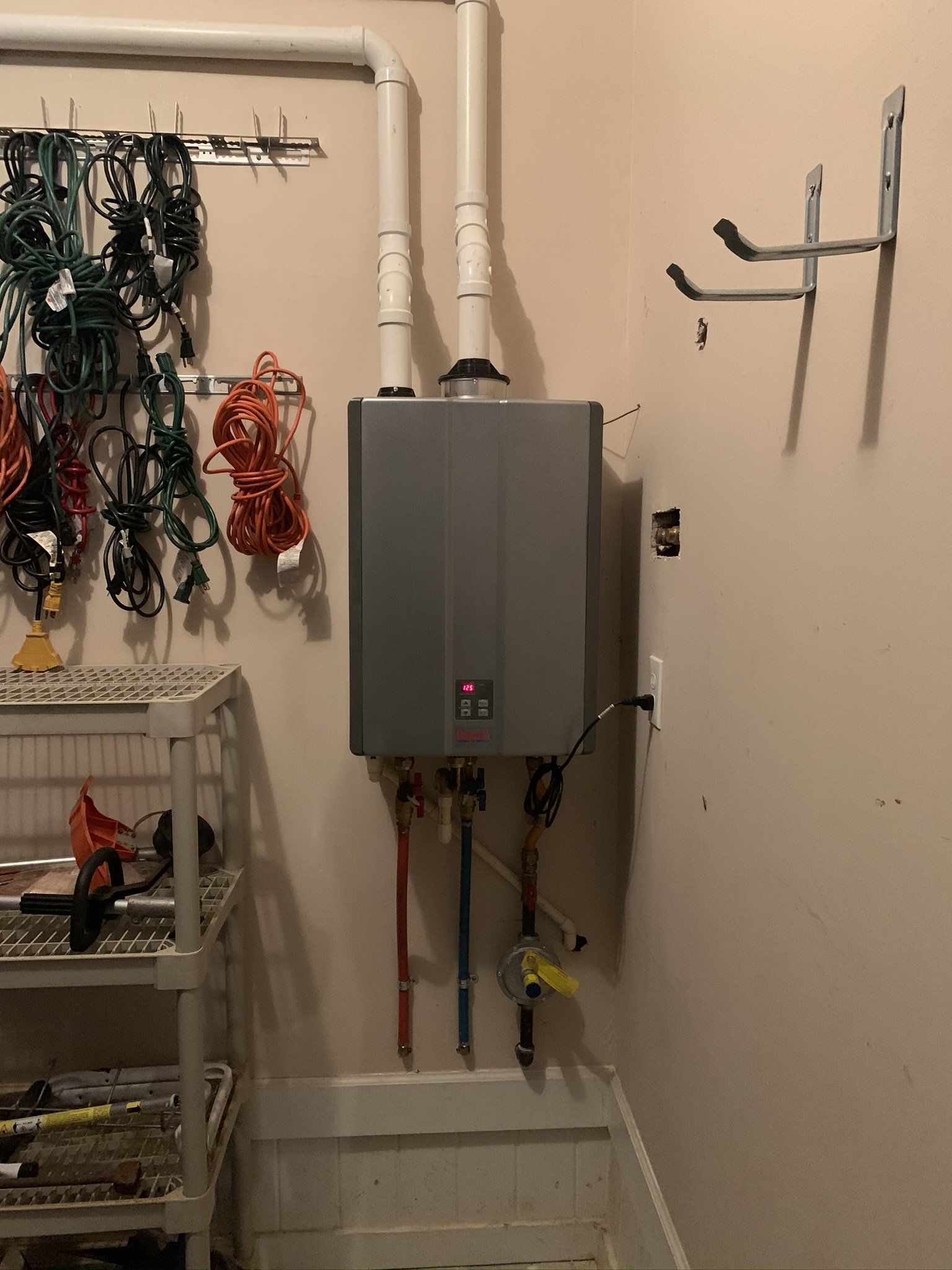 A water heater is mounted to the wall in a room.