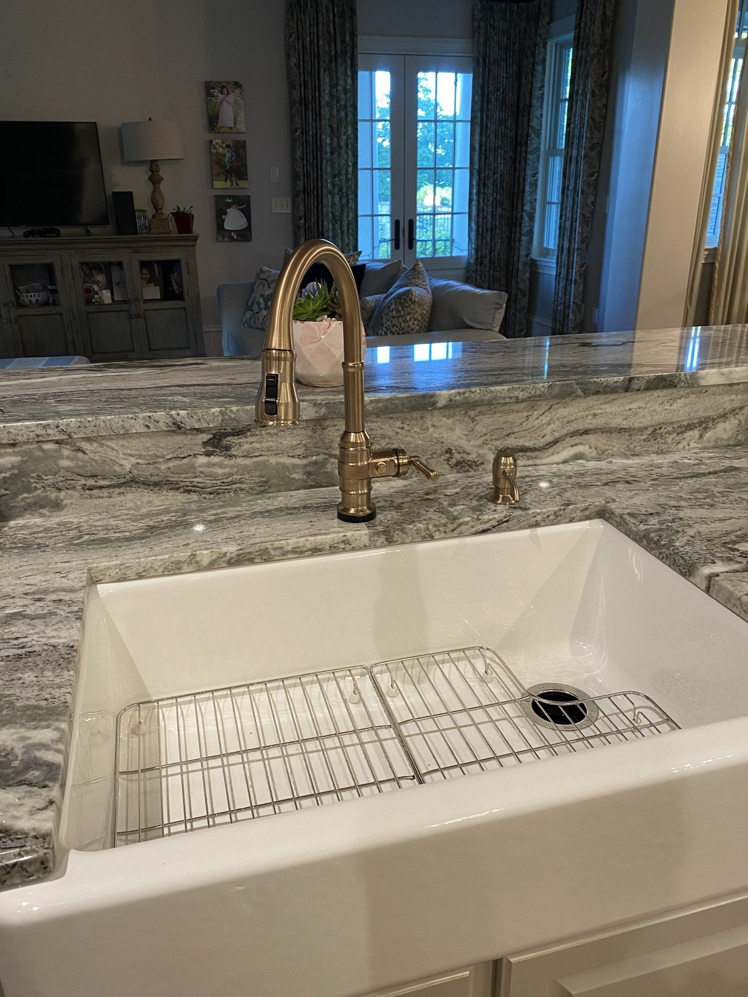 A kitchen sink with a faucet on top of a granite counter top.