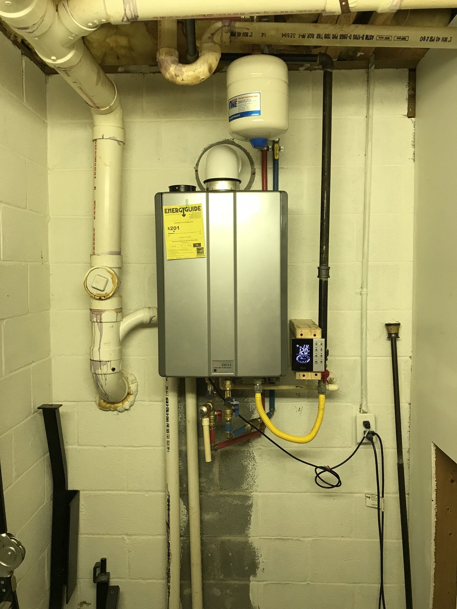 A water heater is hanging from the ceiling in a room.