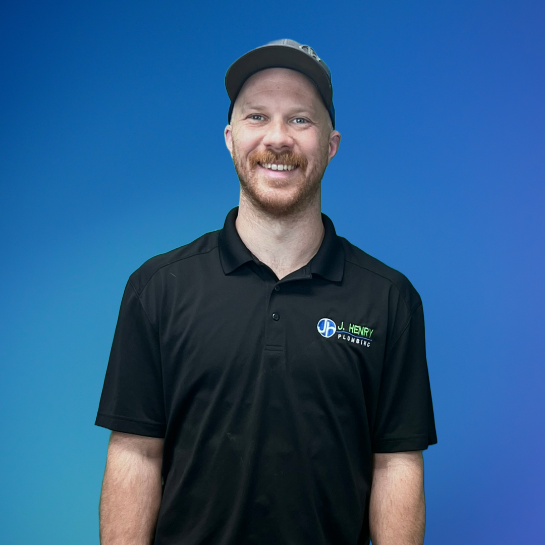 A man wearing a black polo shirt and a hat is smiling for the camera.