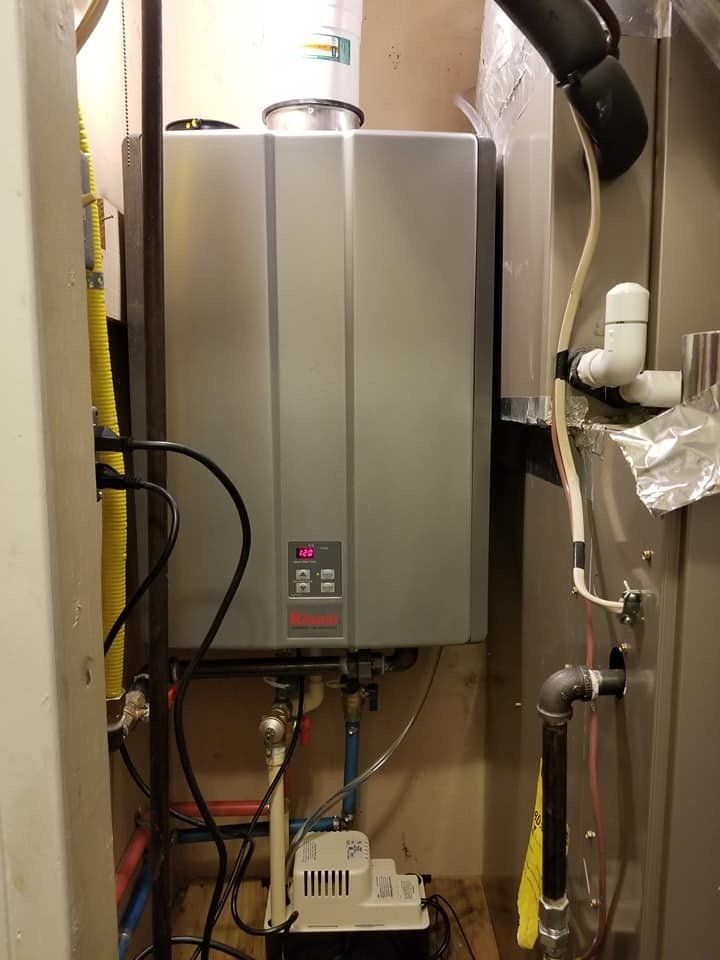 A water heater is sitting in a room next to a wall.