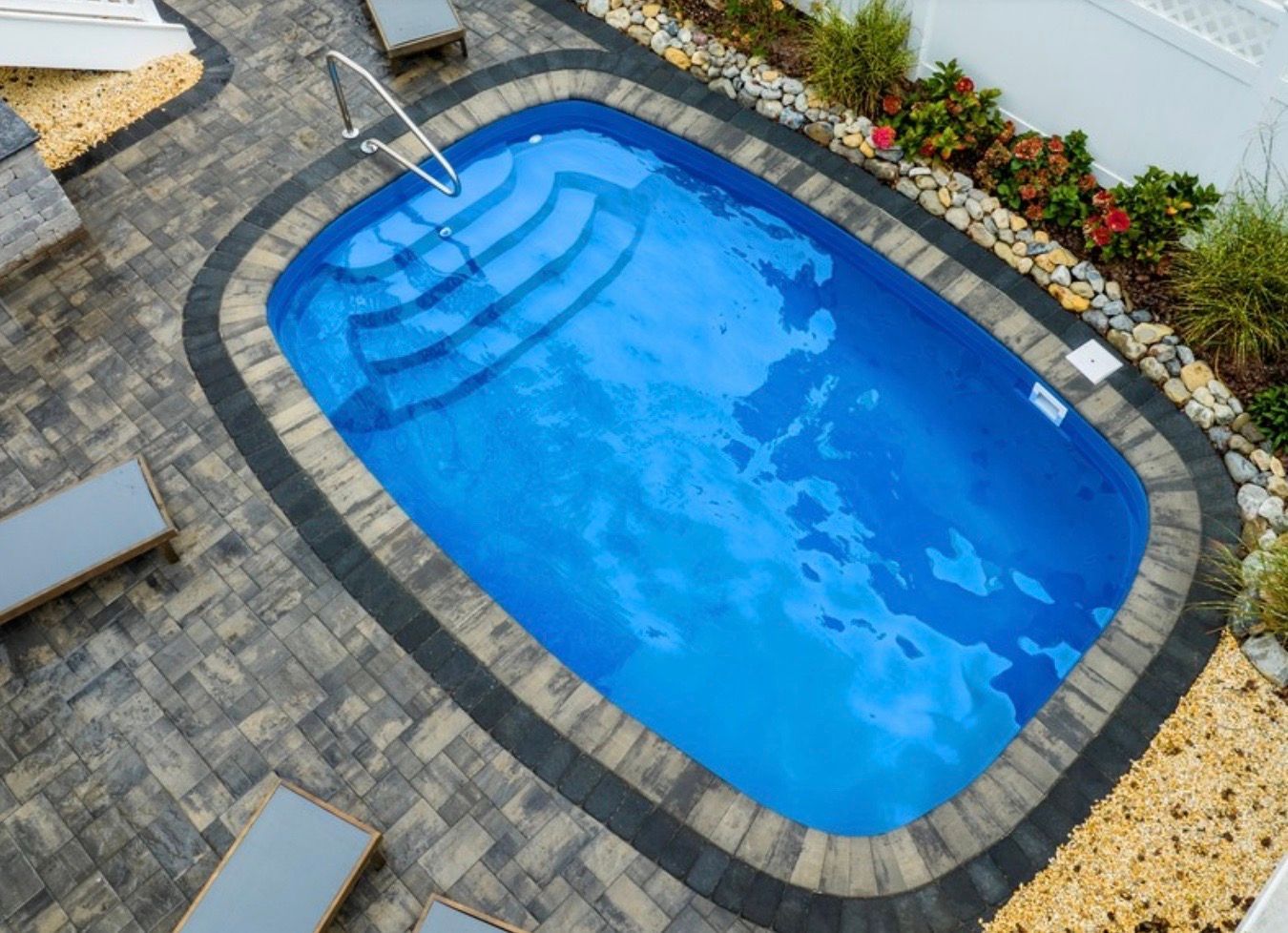 An aerial view of a small swimming pool surrounded by chairs.