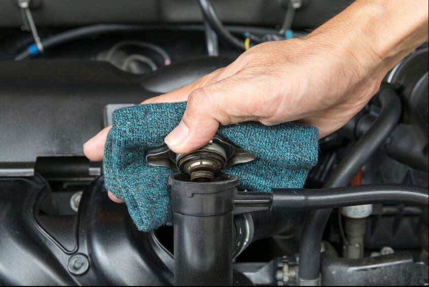 A person is cleaning a radiator with a cloth.