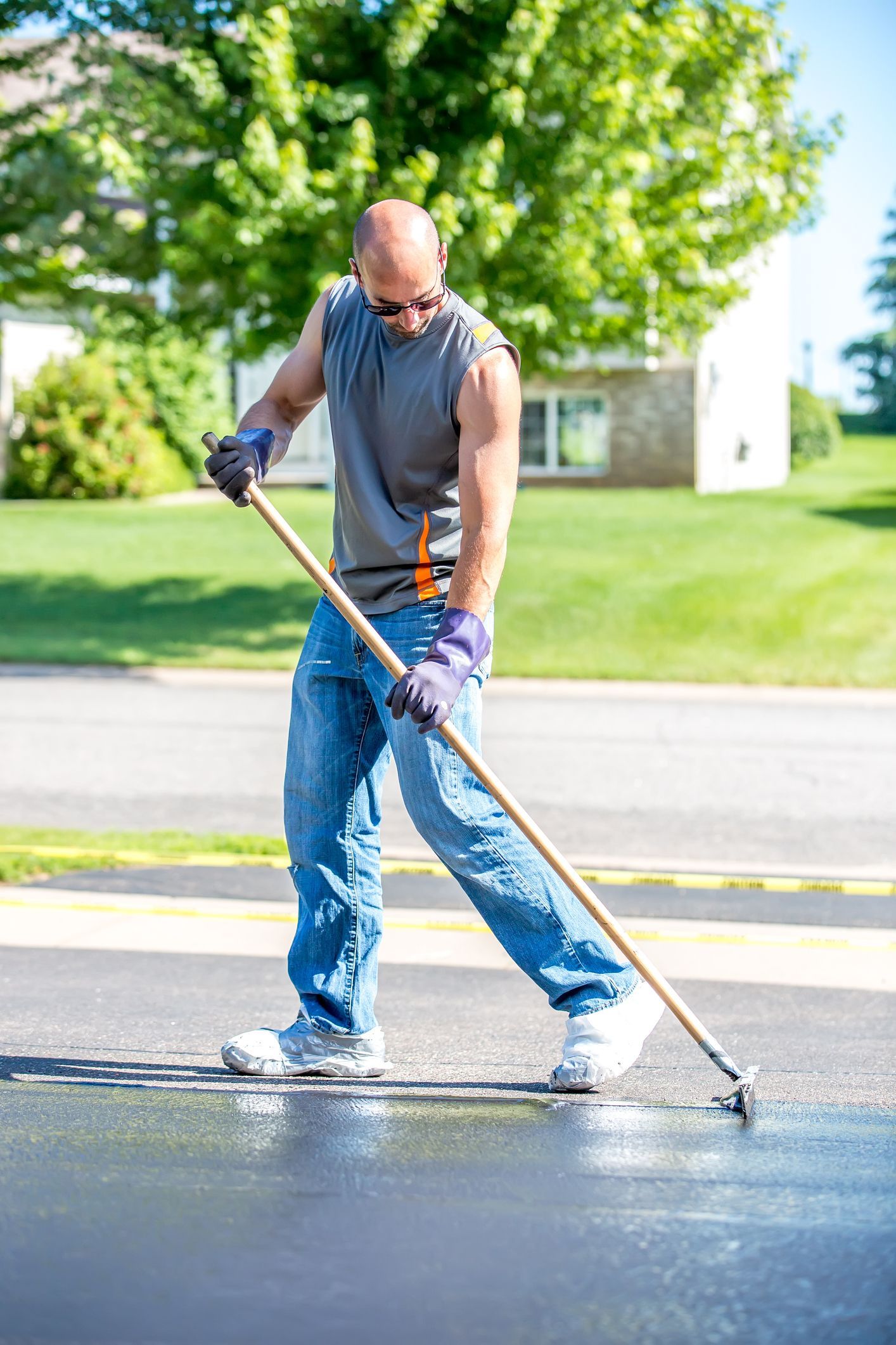 Technician asphalt sealcoating by Premier Asphalt Paving Co. in Cleveland, OH