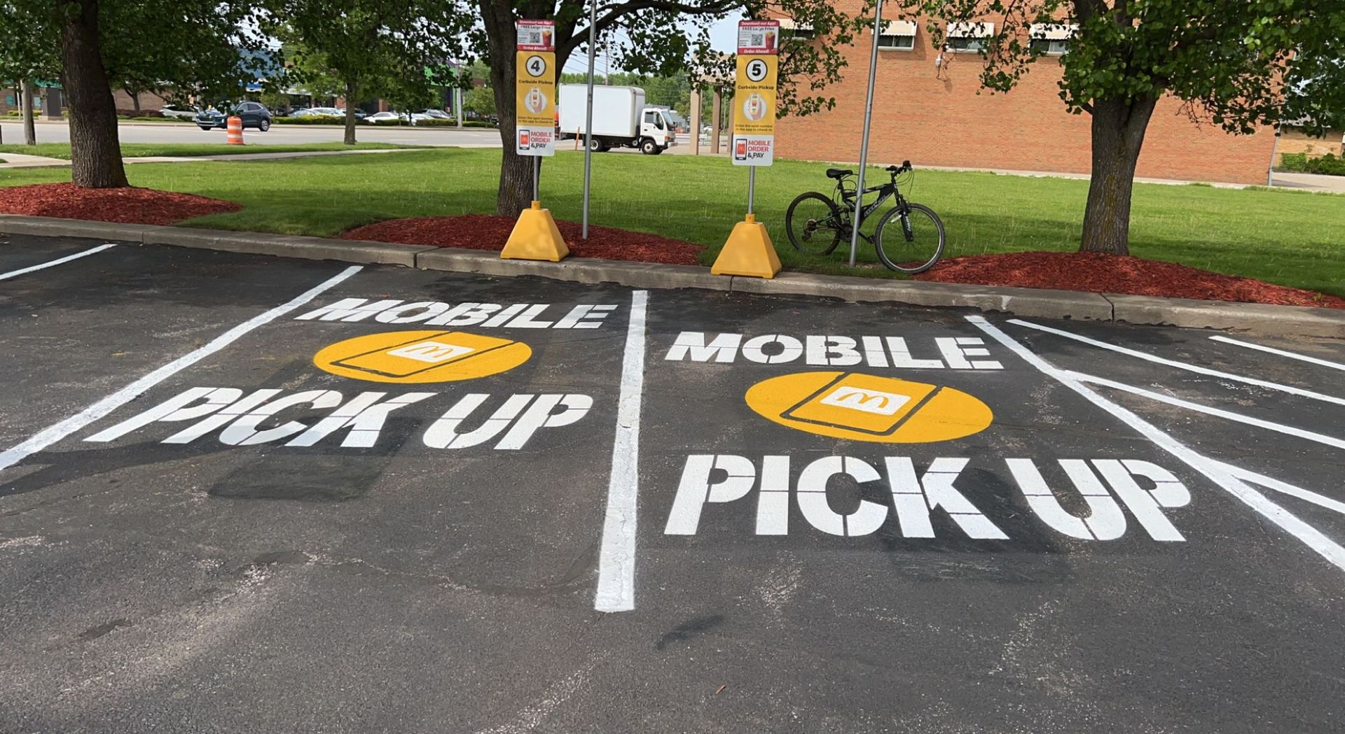 Parking lot pickup zone marked with large white “PICK UP” text and arrows on two lanes.