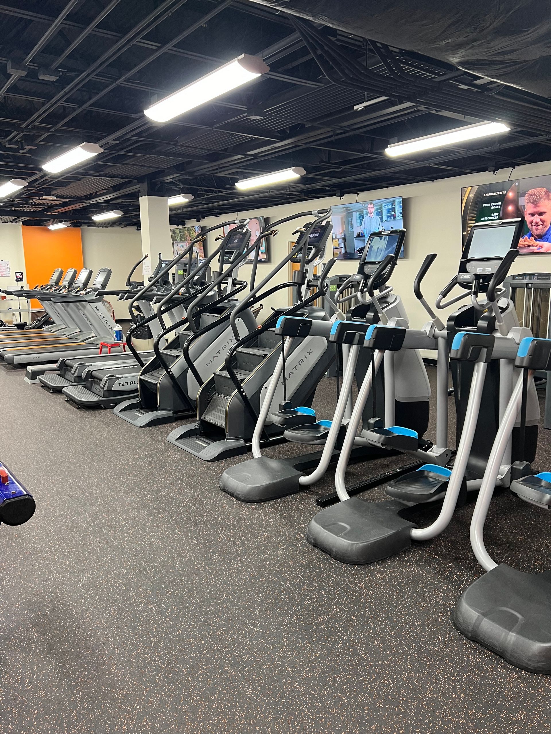 A gym filled with a lot of exercise equipment.