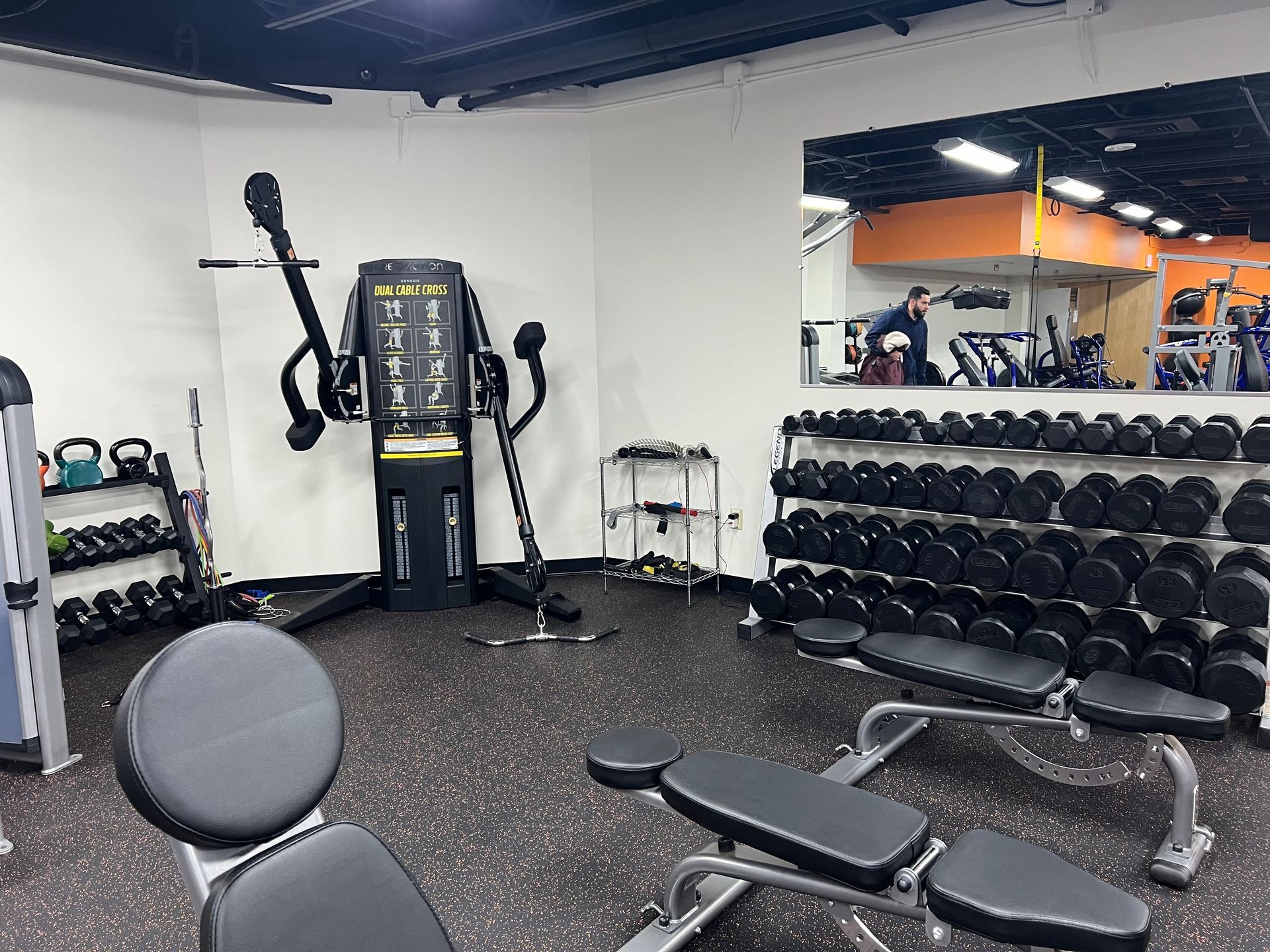 A gym with a lot of dumbbells and a bench.