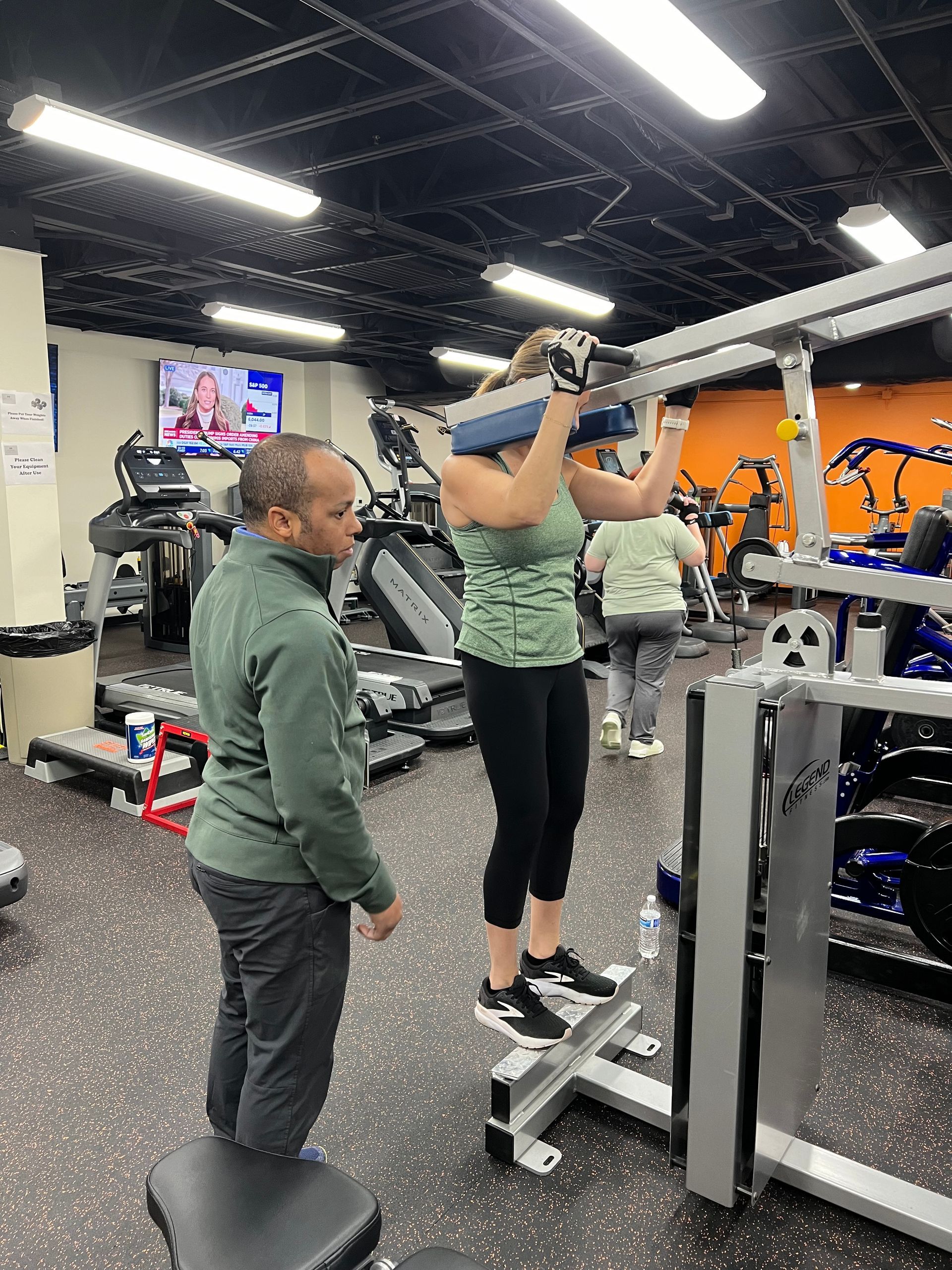 A man is standing next to a woman in a gym.
