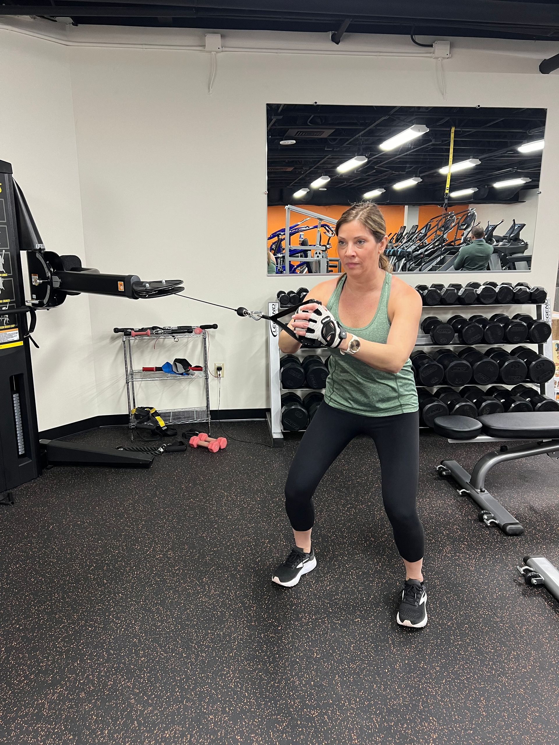A woman is using a machine in a gym.