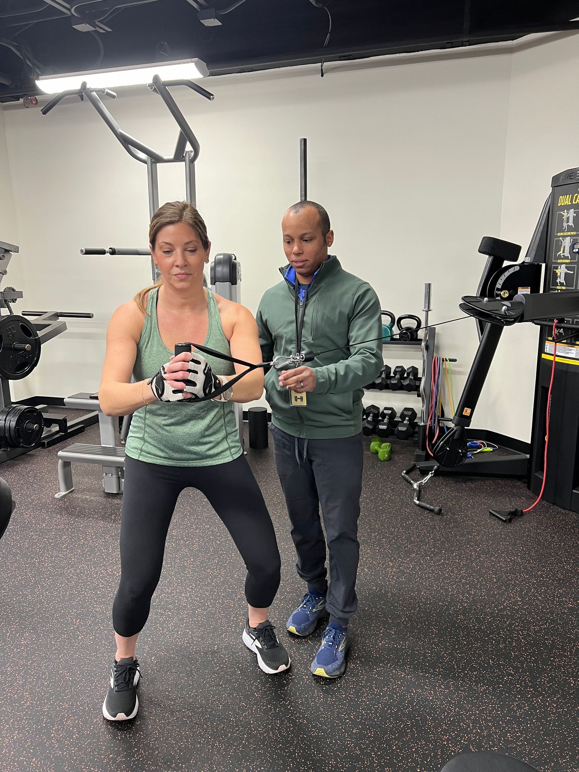 A man and a woman are standing next to each other in a gym.