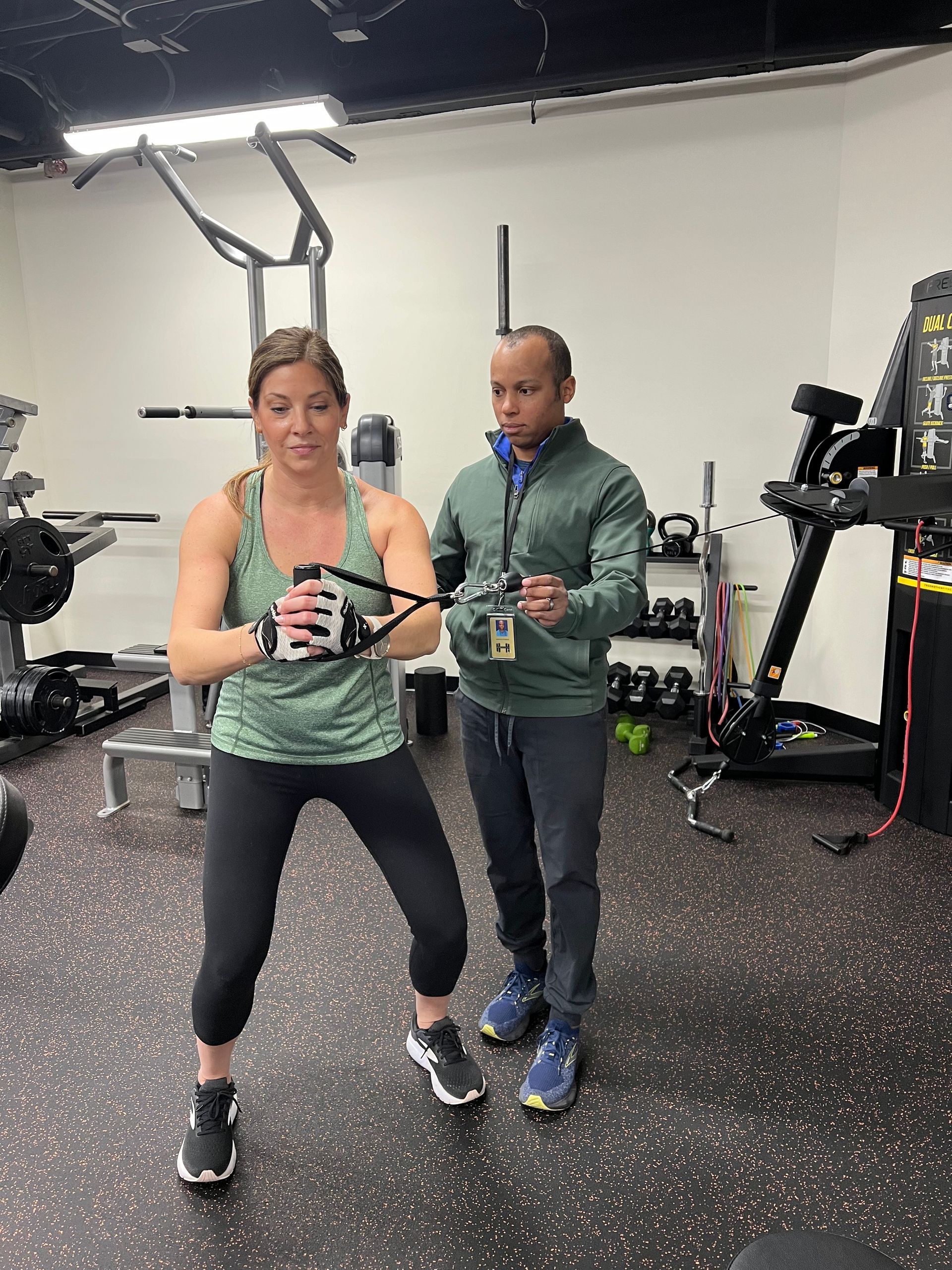 A man and a woman are standing in a gym.