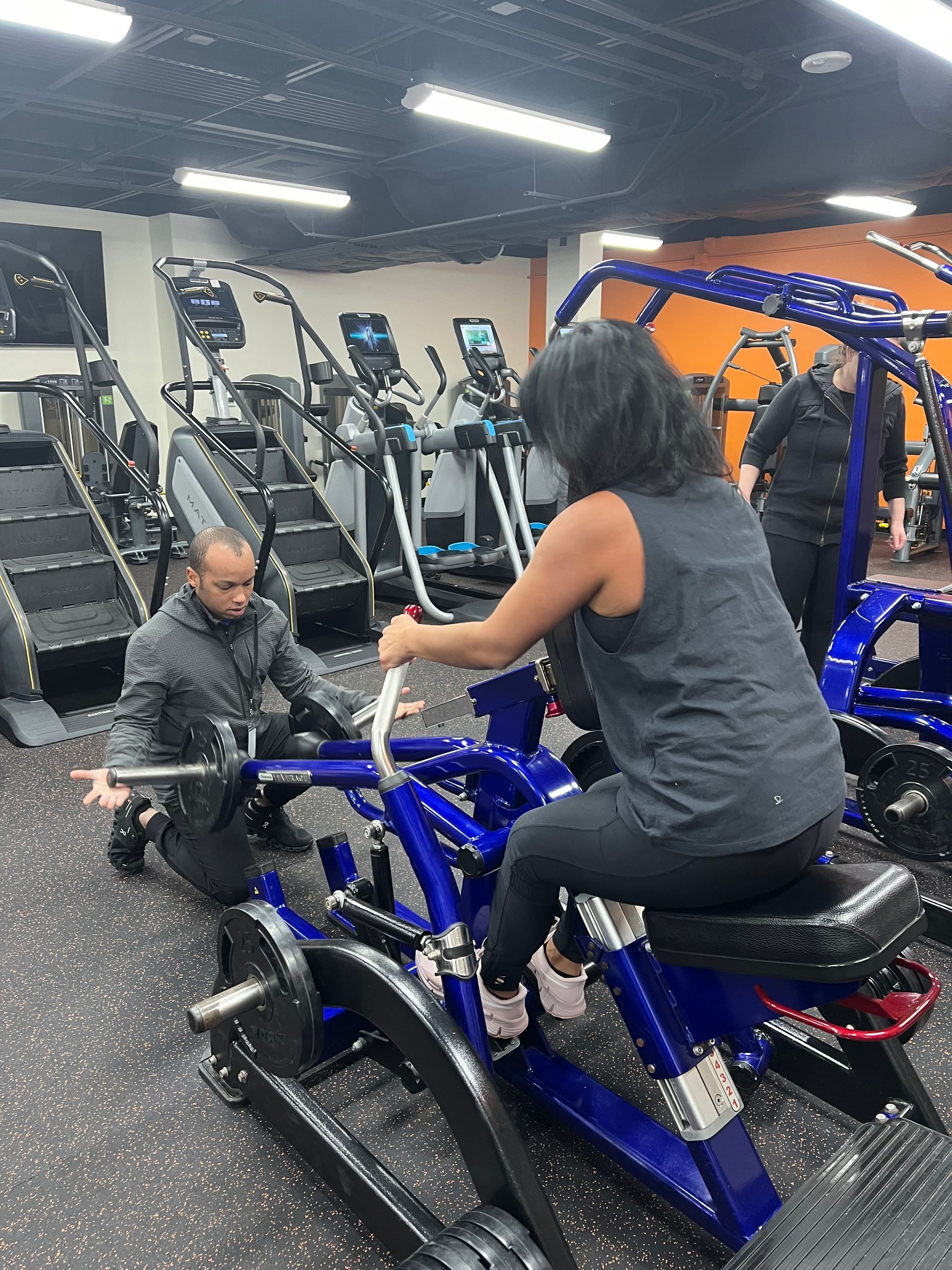A woman is riding a machine in a gym.