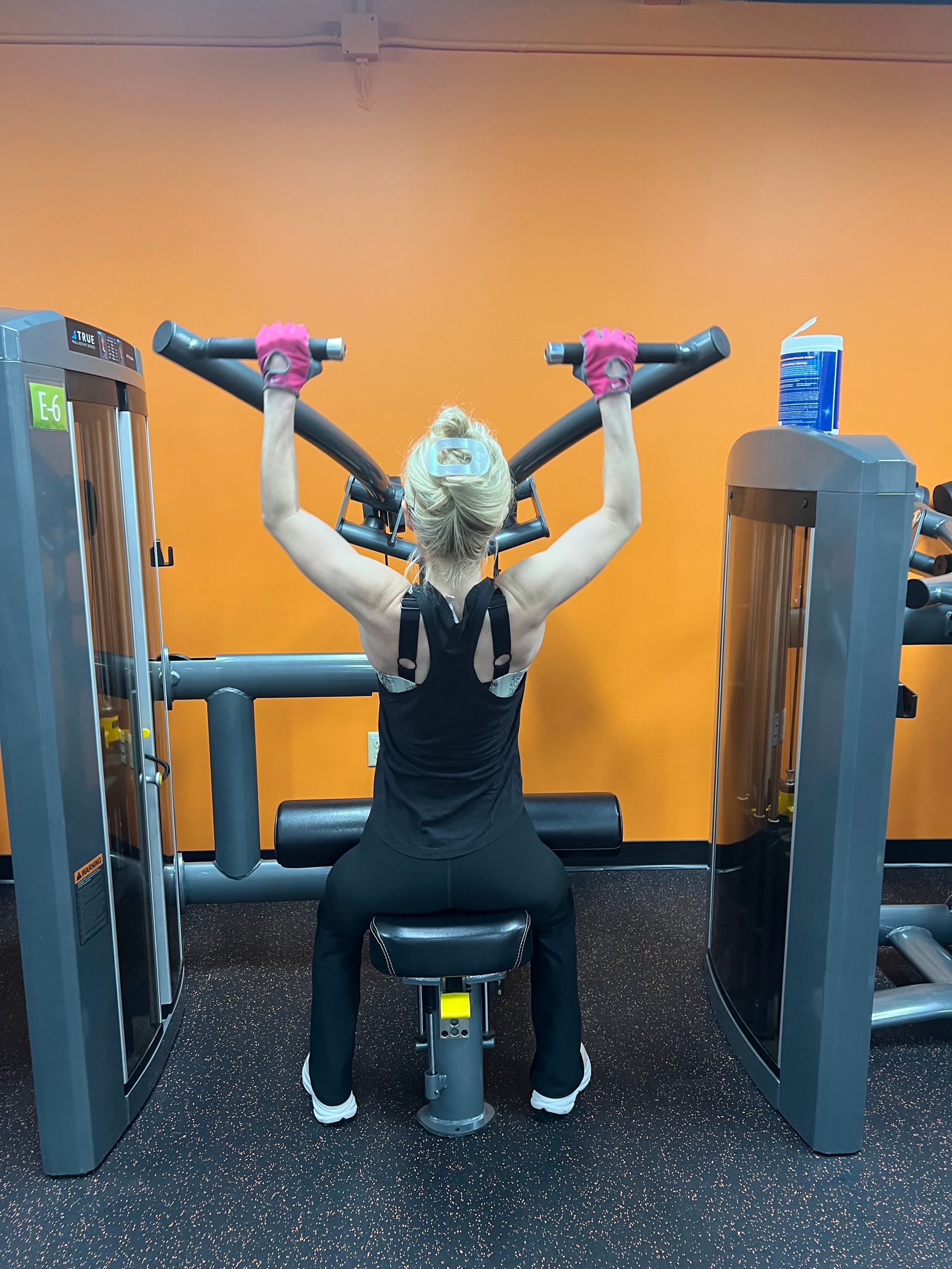 A woman is doing exercises on a machine with the number 00 on her back