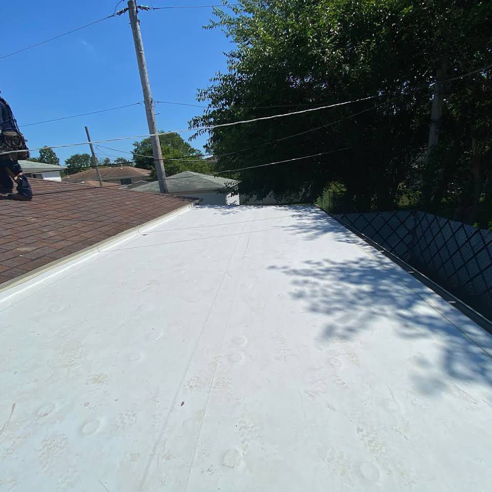 White flat roof with some footprints, under a bright blue sky.
