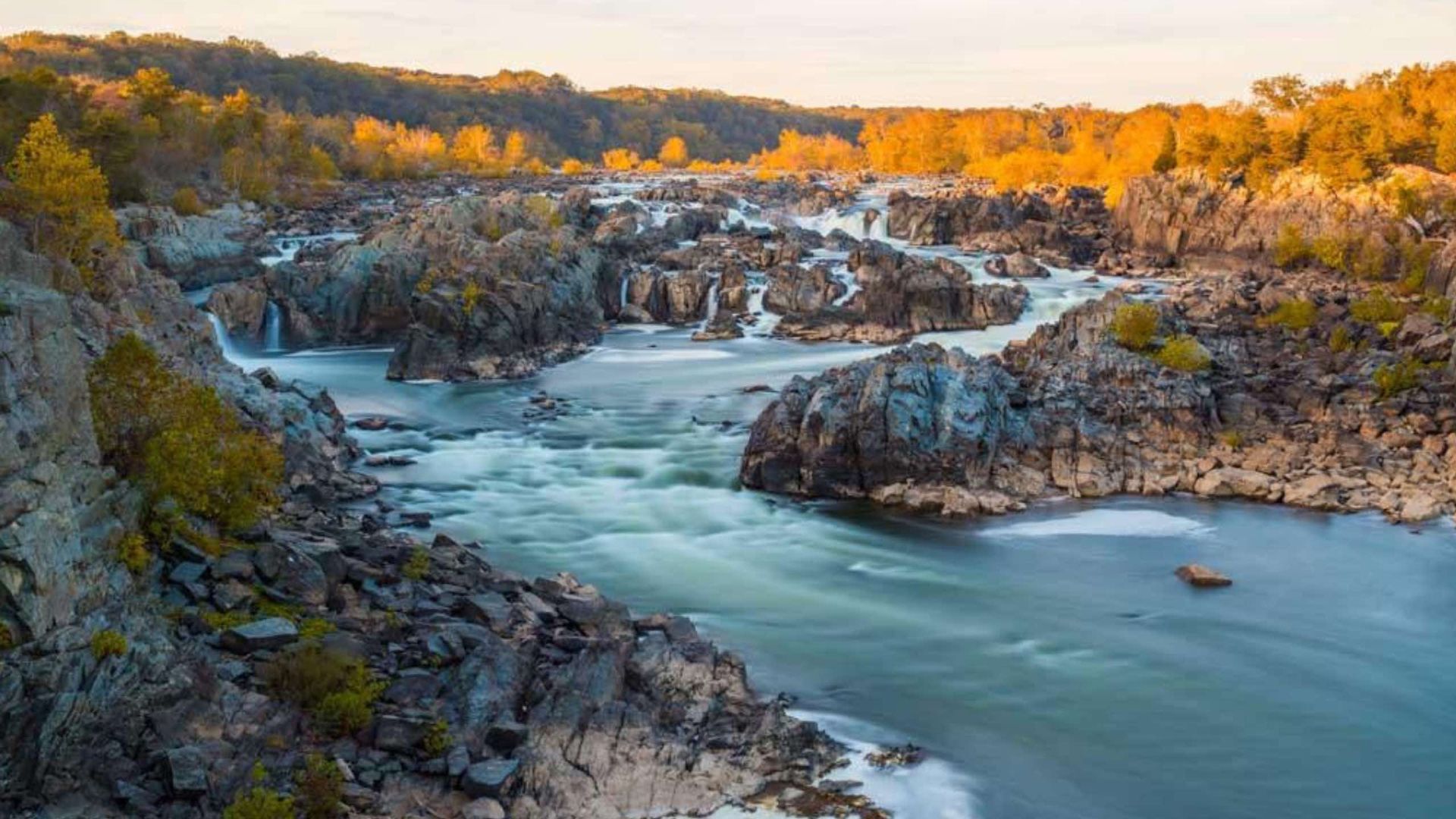River flowing through rocky terrain, surrounded by trees.