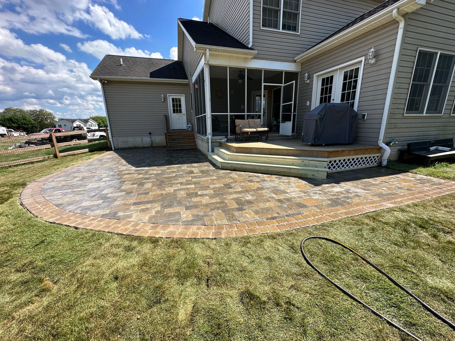A large house with a screened in porch and patio.