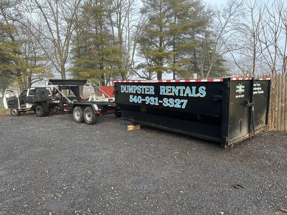 A dumpster rental truck is parked next to a dumpster in a parking lot.