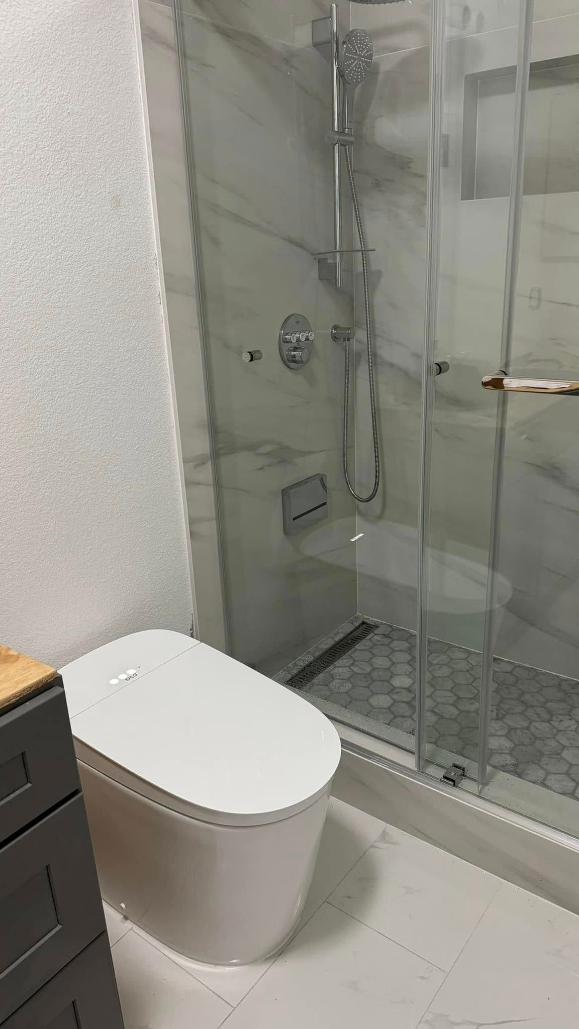 A bathroom with a toilet and a shower stall.