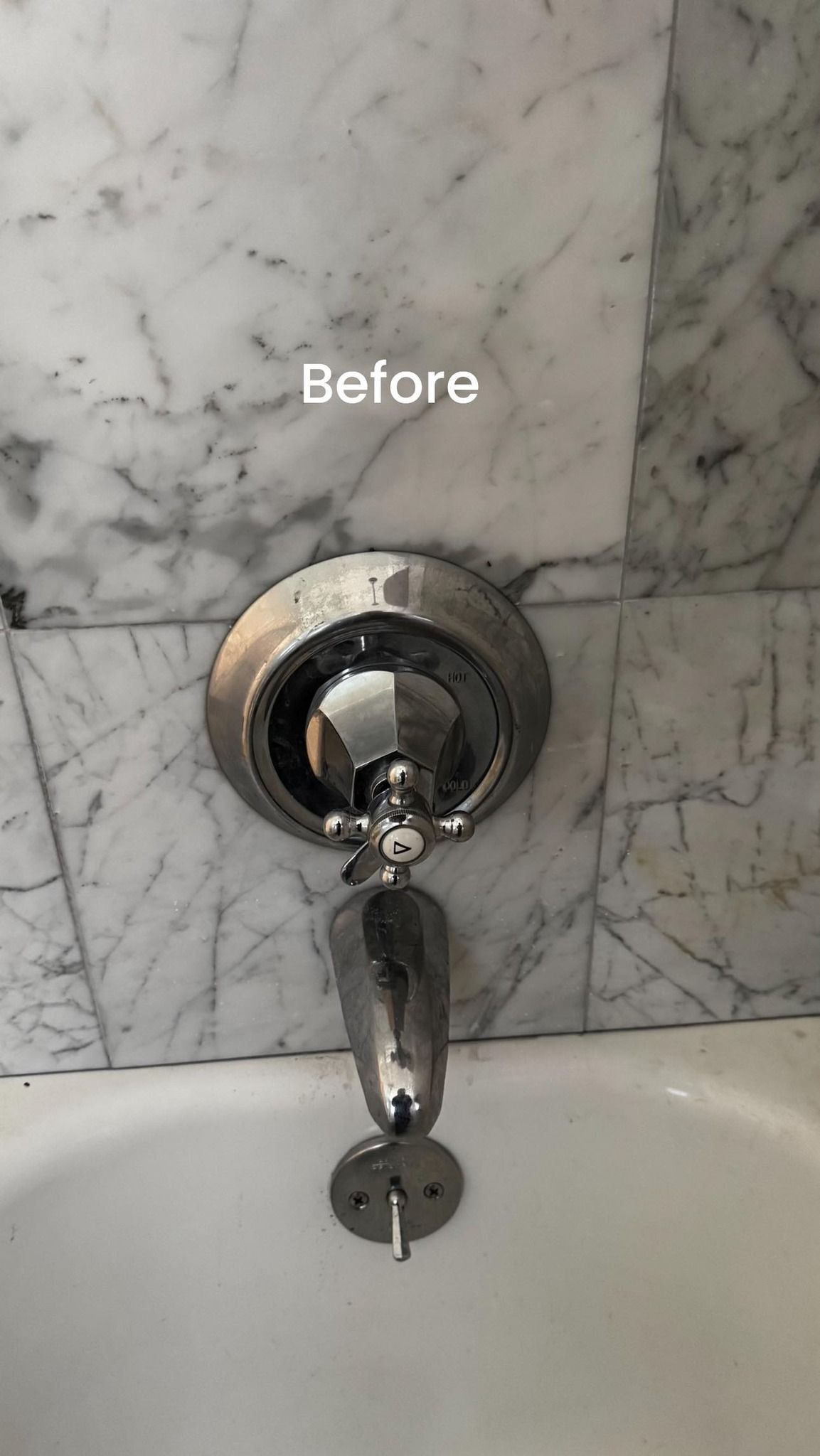 A bathtub with a shower head attached to the wall.