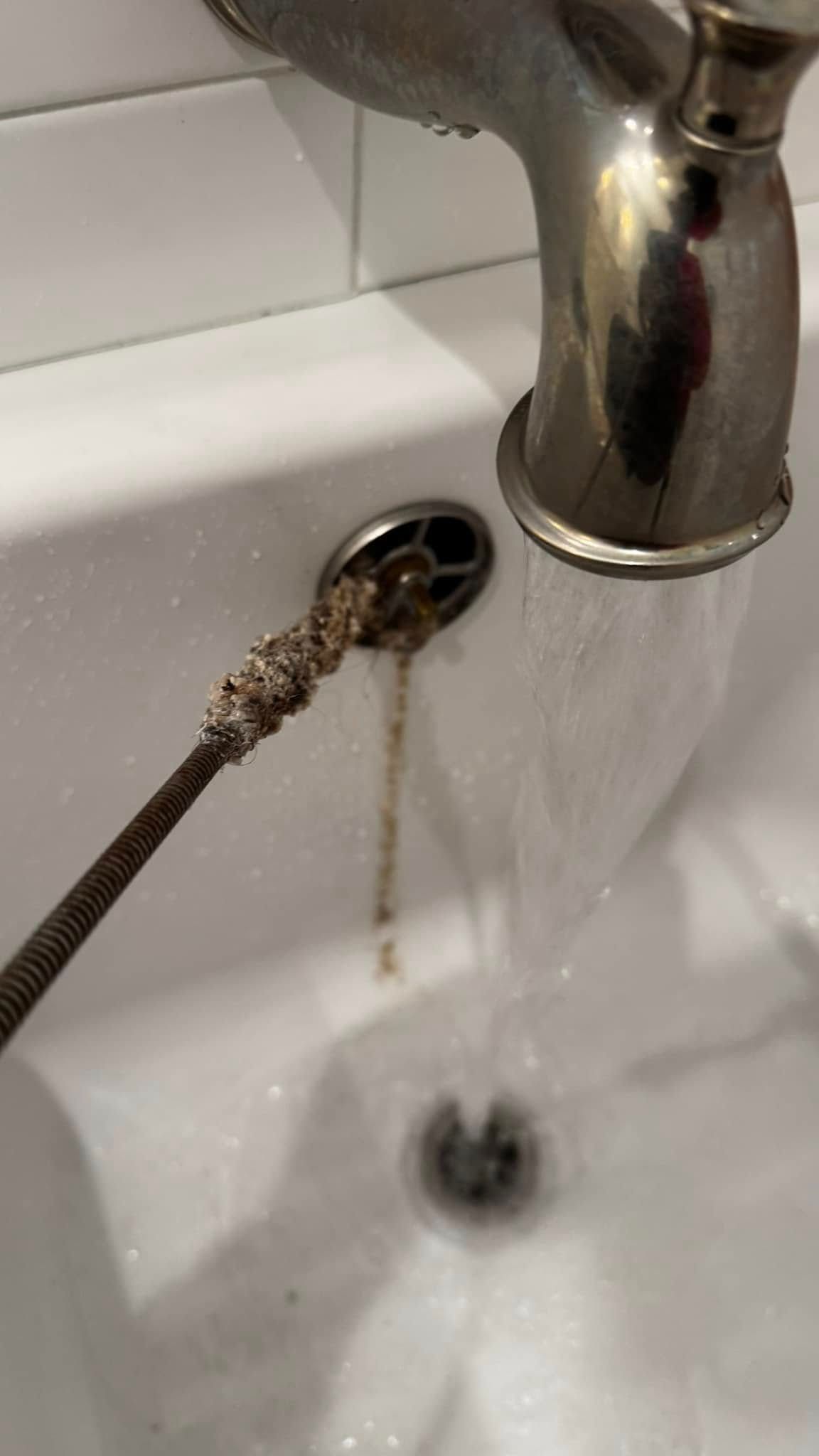 A close up of a sink faucet with water running out of it.