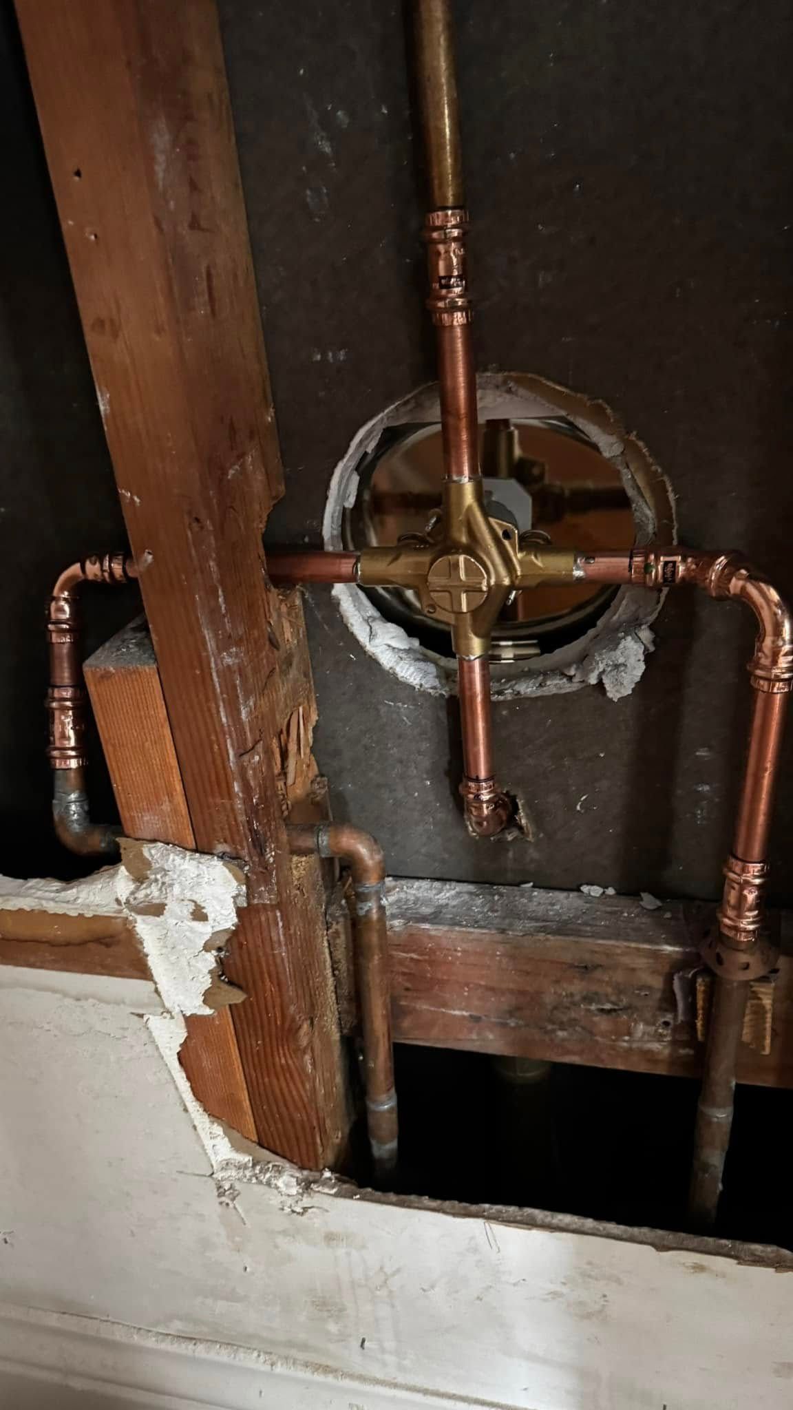 A close up of a copper pipe in a bathroom.