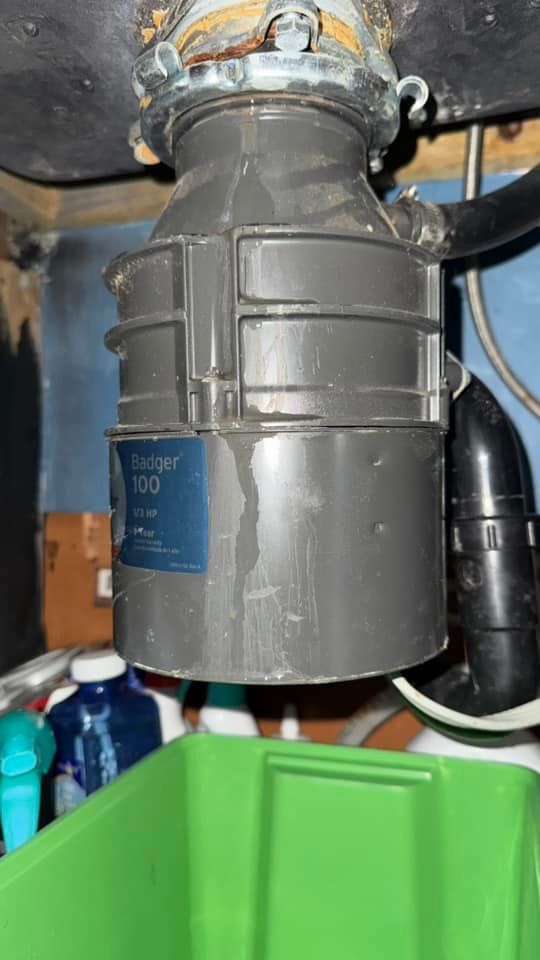 A garbage disposal is sitting under a sink in a kitchen.