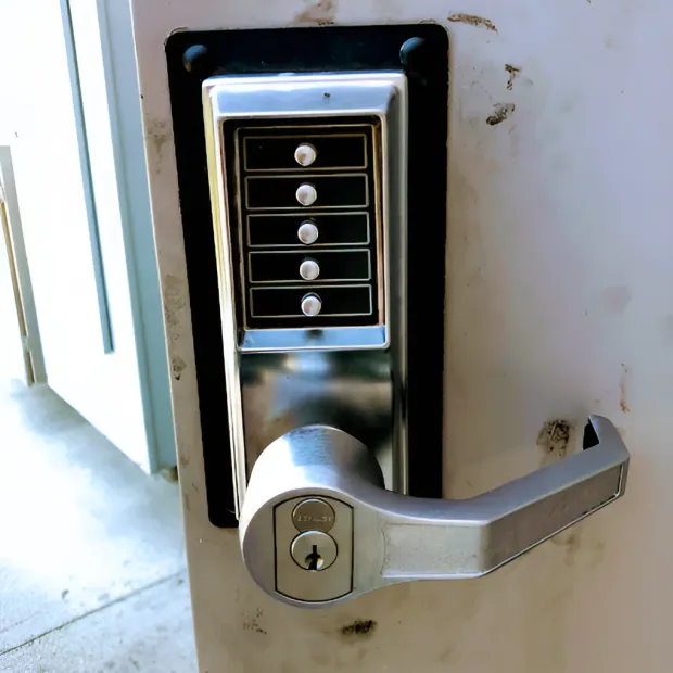 A silver door lever handle with an integrated five-button keypad lock, mounted on a white door.