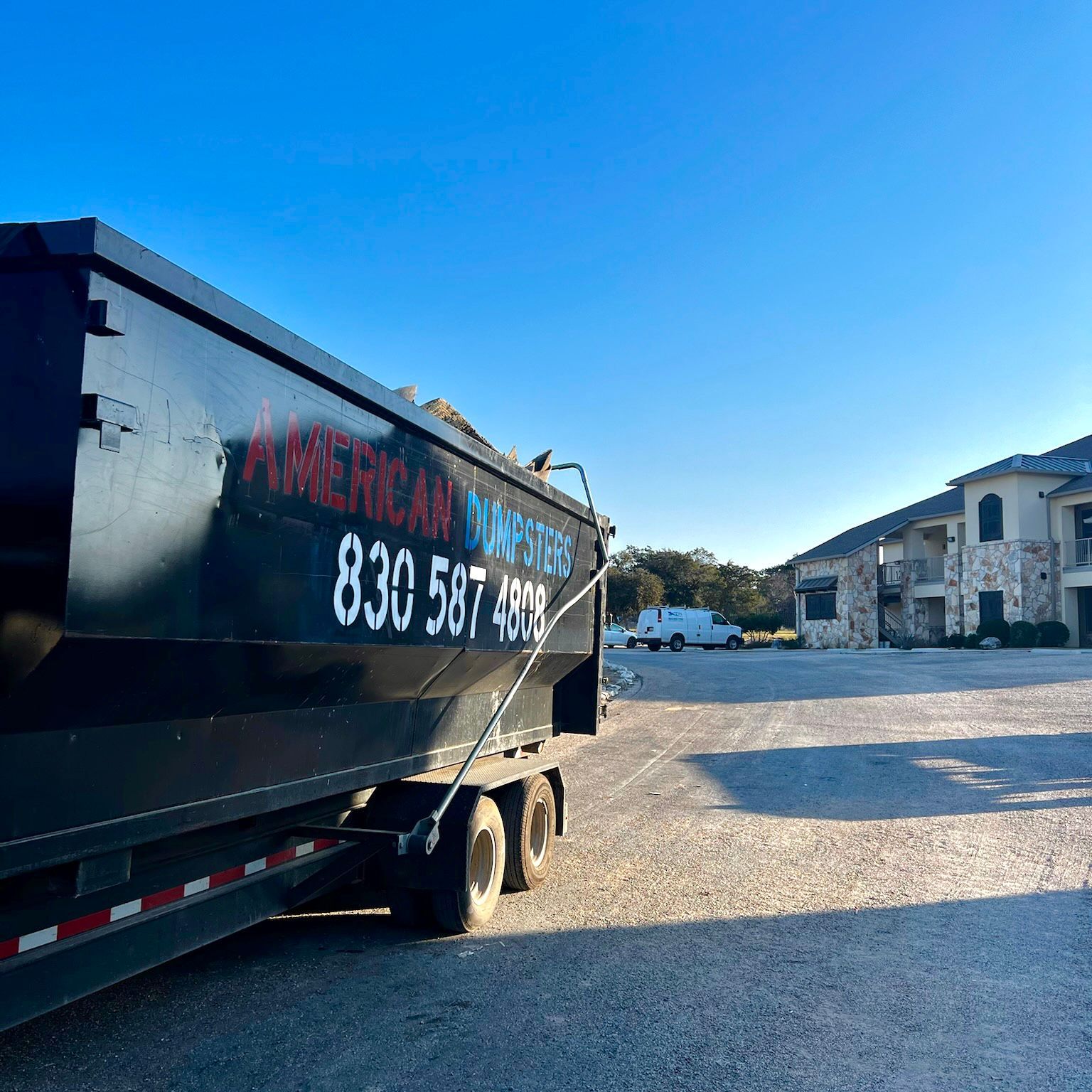 Photo of American Dumpsters Roll-Off Dumpster in front of apartment building