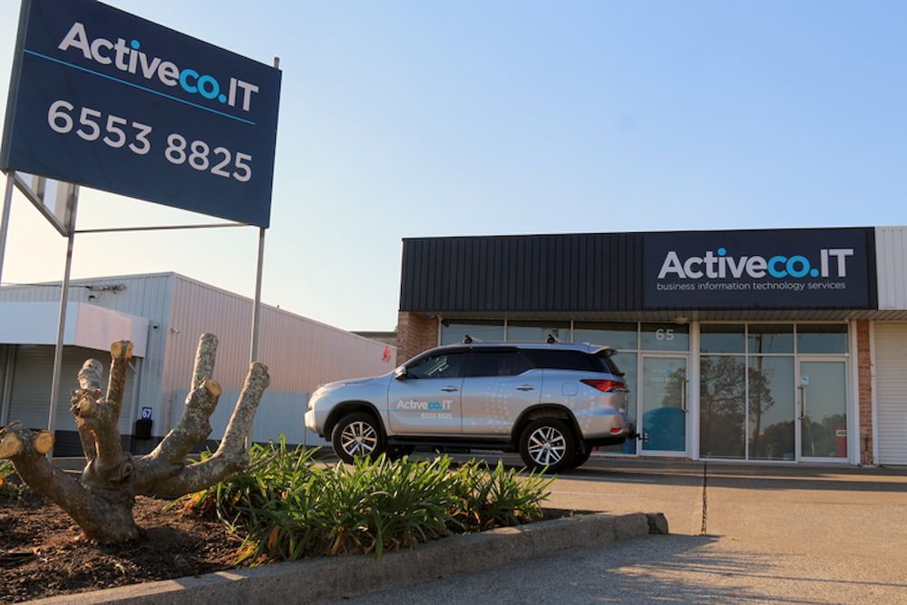 A White Suv Is Parked In Front Of A Building — ActiveCo.IT in Taree, NSW