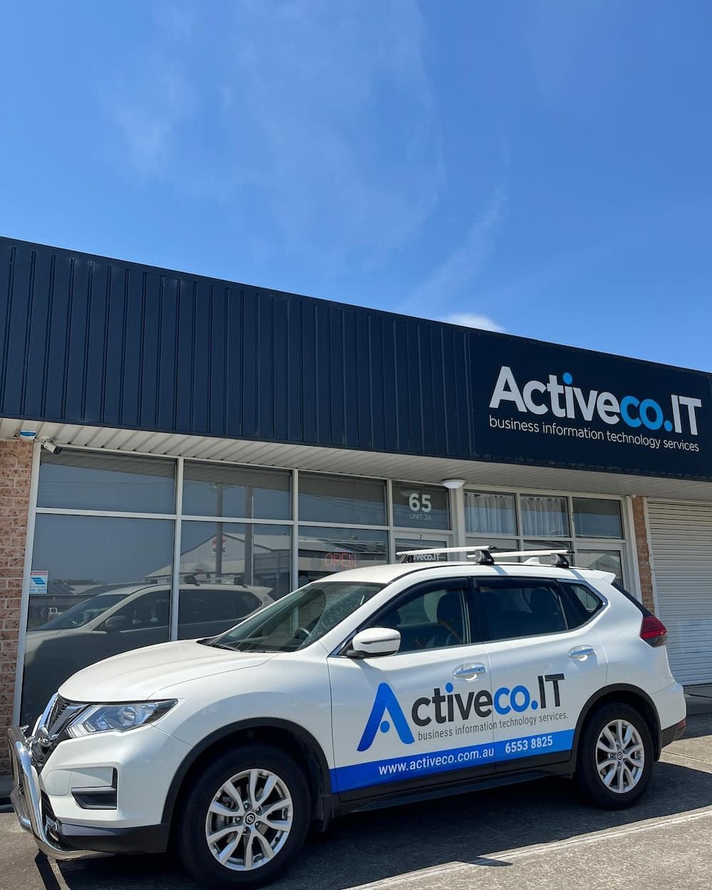 A White Car Is Parked In Front Of A Building — ActiveCo.IT in Taree, NSW