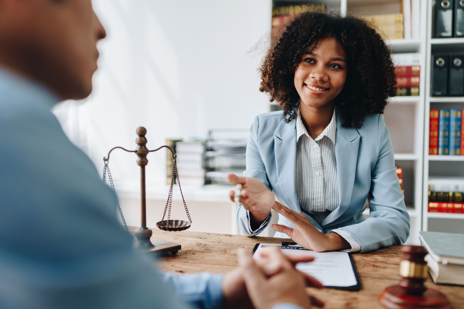 A woman is sitting at a table talking to a man. Ledbetter Anderson & Associates Law Firm, Houston TX, Estate Planning and Probate 