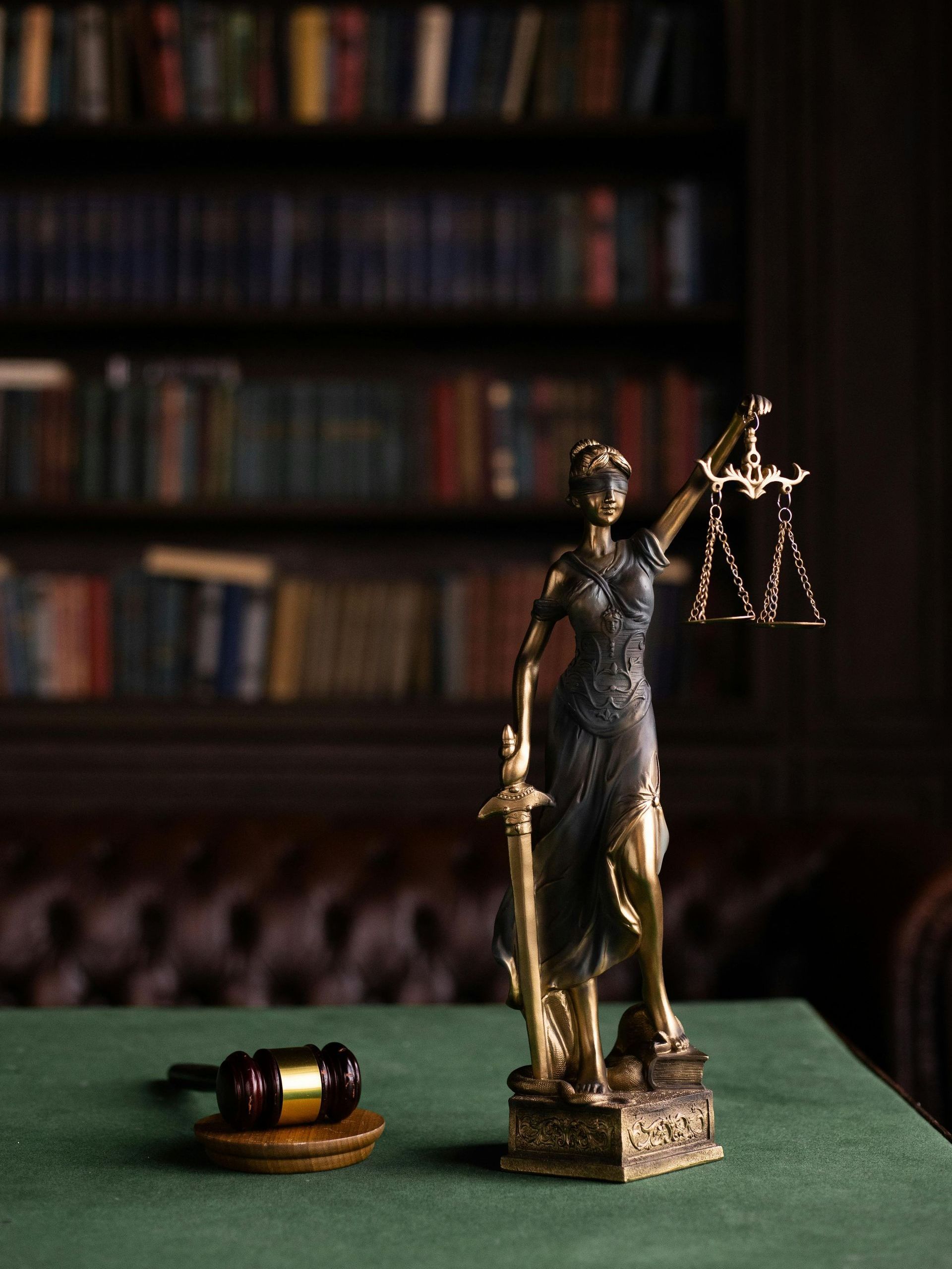 A statue of justice holding scales of justice and a gavel on a table. Ledbetter Anderson & Associates Law Firm, Houston TX, Estate Planning and Probate 