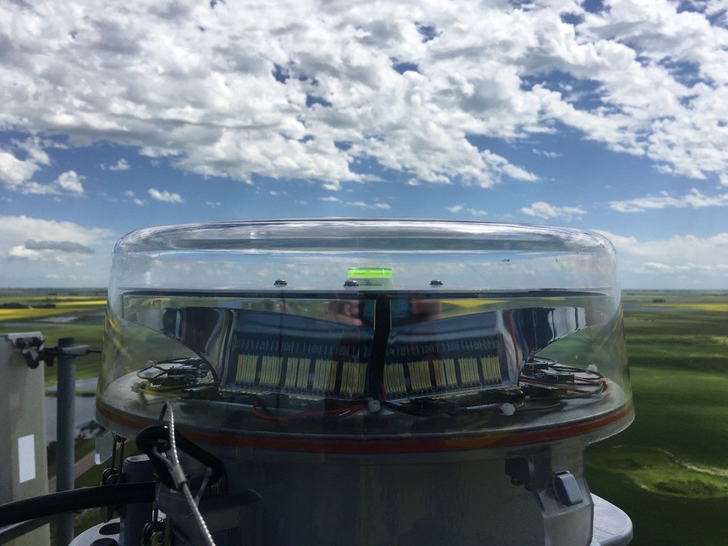 A Large Glass Dome with A Reflection of A Field in It.