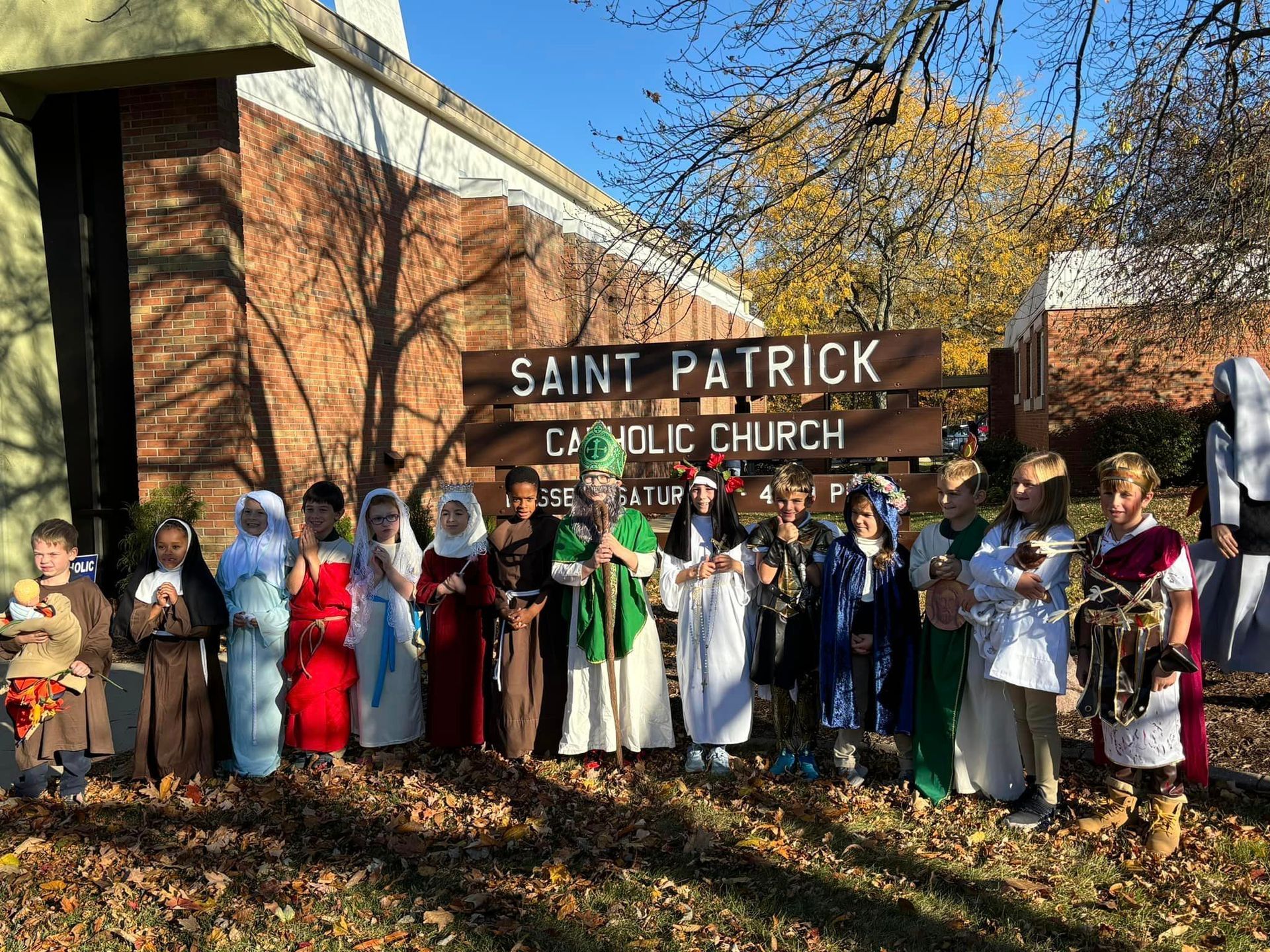 Children in costumes pose in front of 