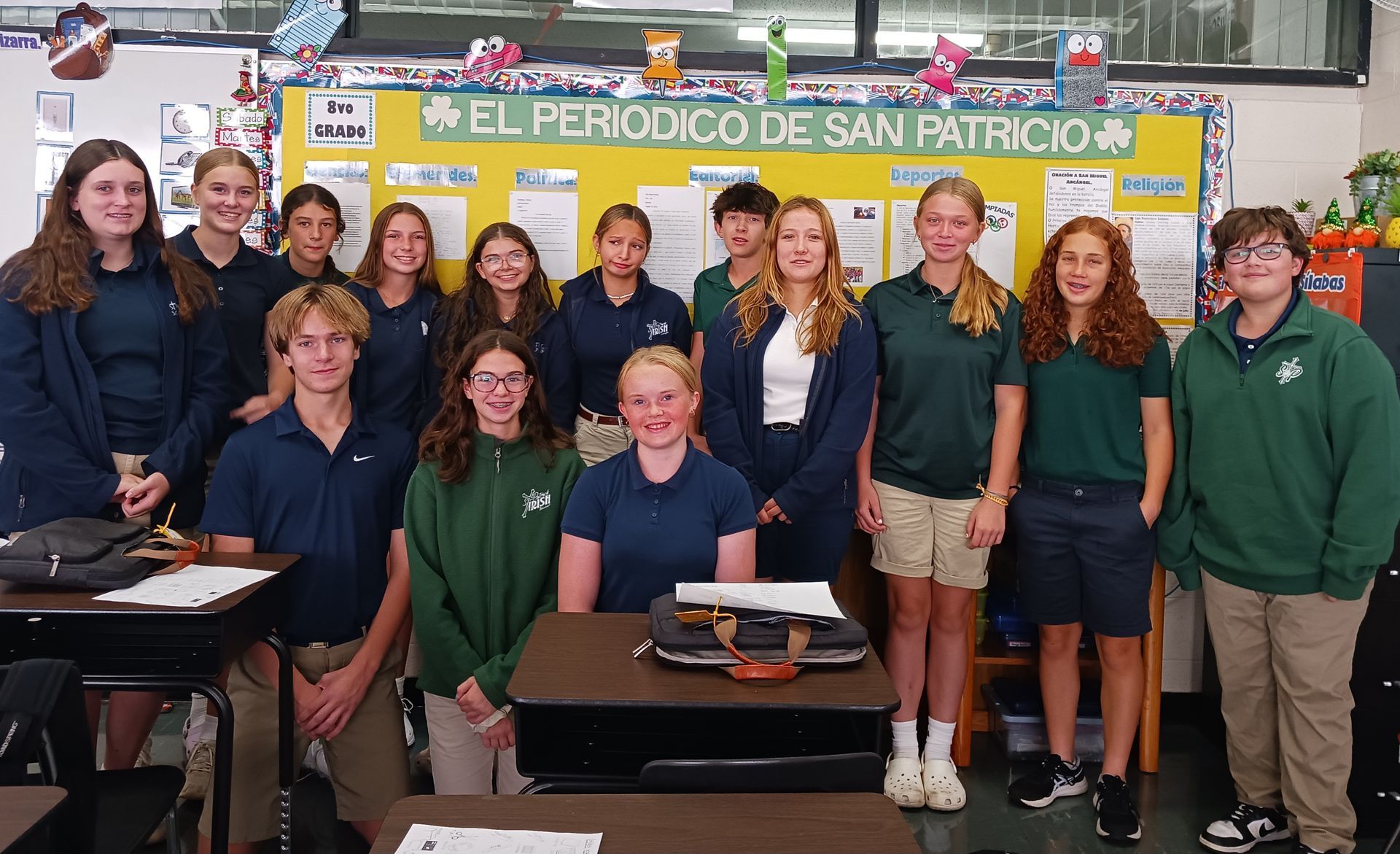 Students in a classroom posing for a photo with a Spanish language board.