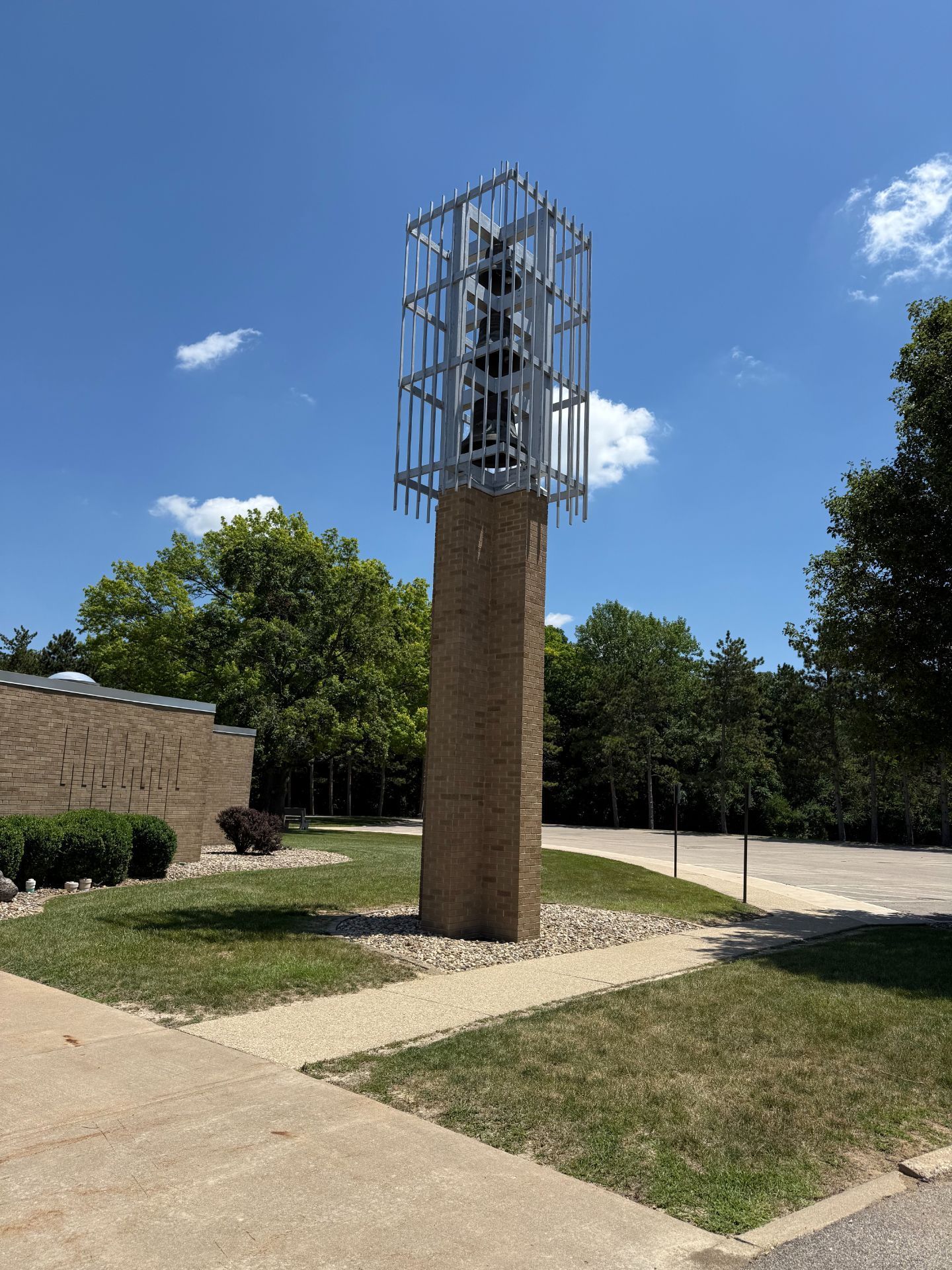 A tall brick pillar with a caged metal structure on top, set outside on a sunny day.