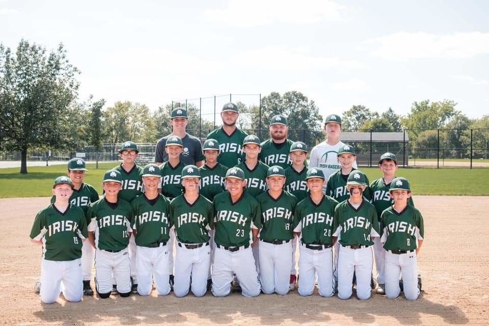 Youth baseball team, the Irish, in green and white uniforms, posing on a baseball field for a team photo.