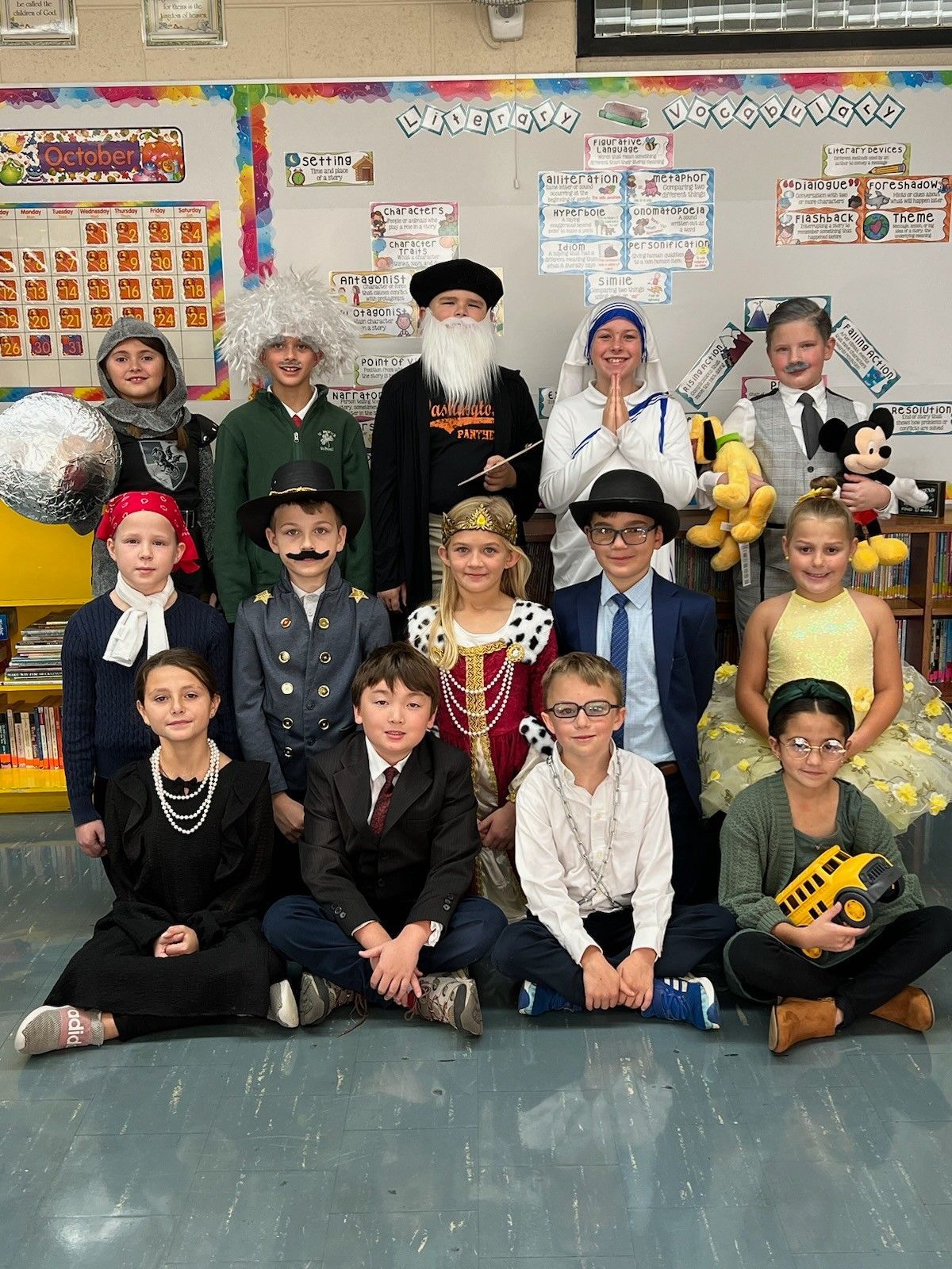 Children in costume, representing historical figures, posing together in a classroom.