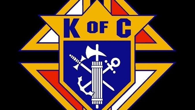Knights of Columbus emblem: gold, blue, and white with the letters 