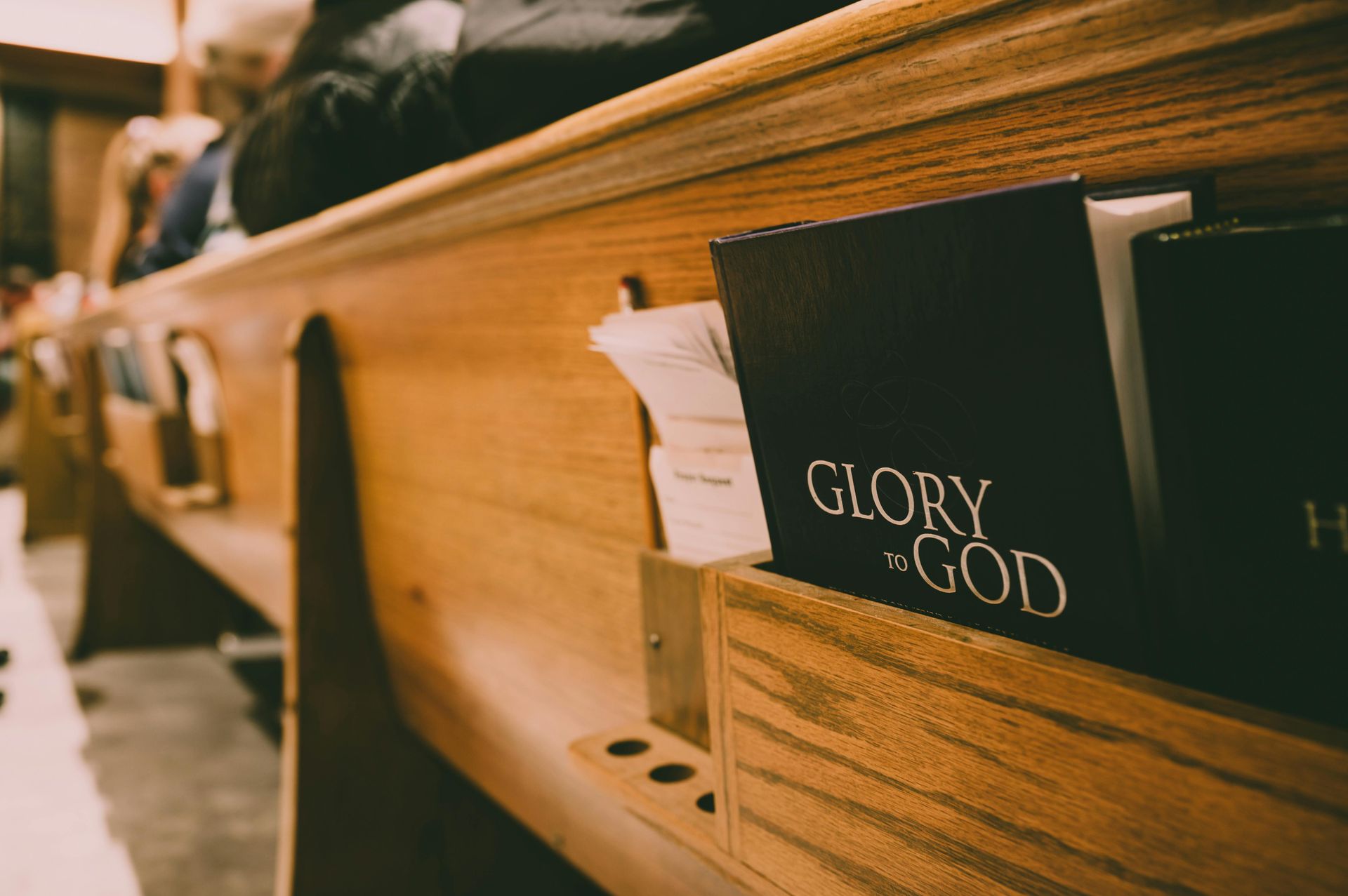 Wooden church pew with a book that reads 