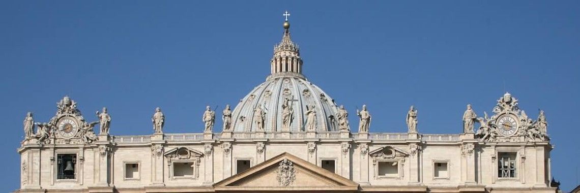 The dome of St. Peter's Basilica, Vatican City, against a clear blue sky.