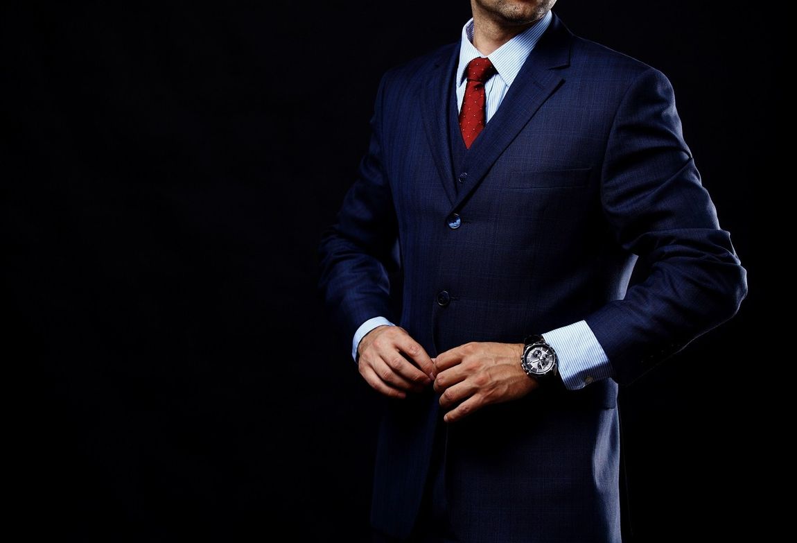 uomo con abito da sposo blu e cravatta rossa