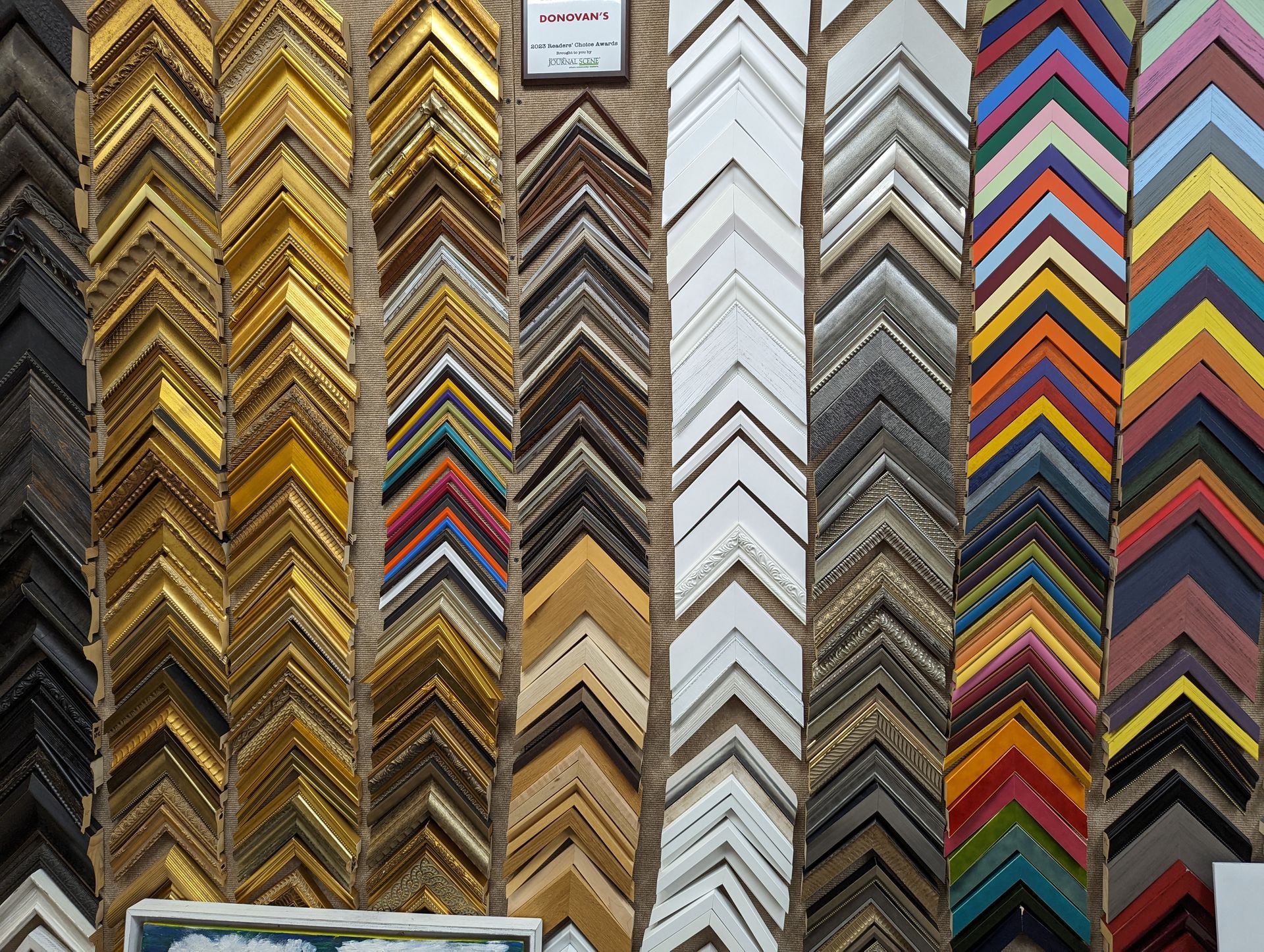 Rows of angled picture frame samples in various colors and finishes.