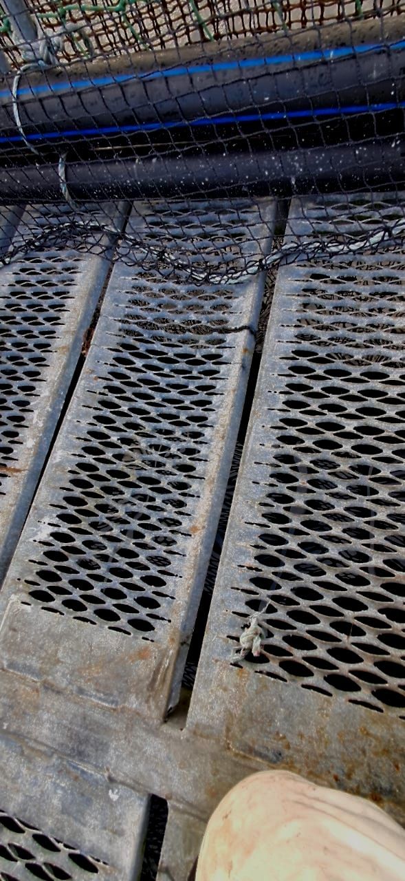 Un primer plano de una rejilla de metal con tuberías que salen de ella.