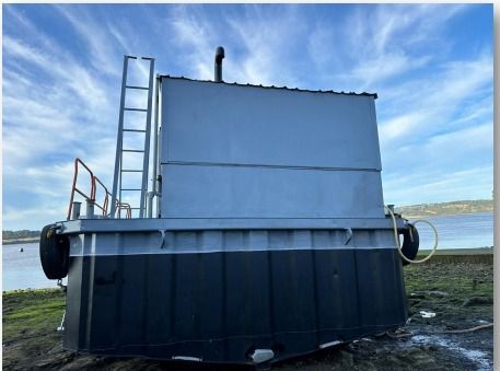 Un gran contenedor de metal con una escalera adjunta.